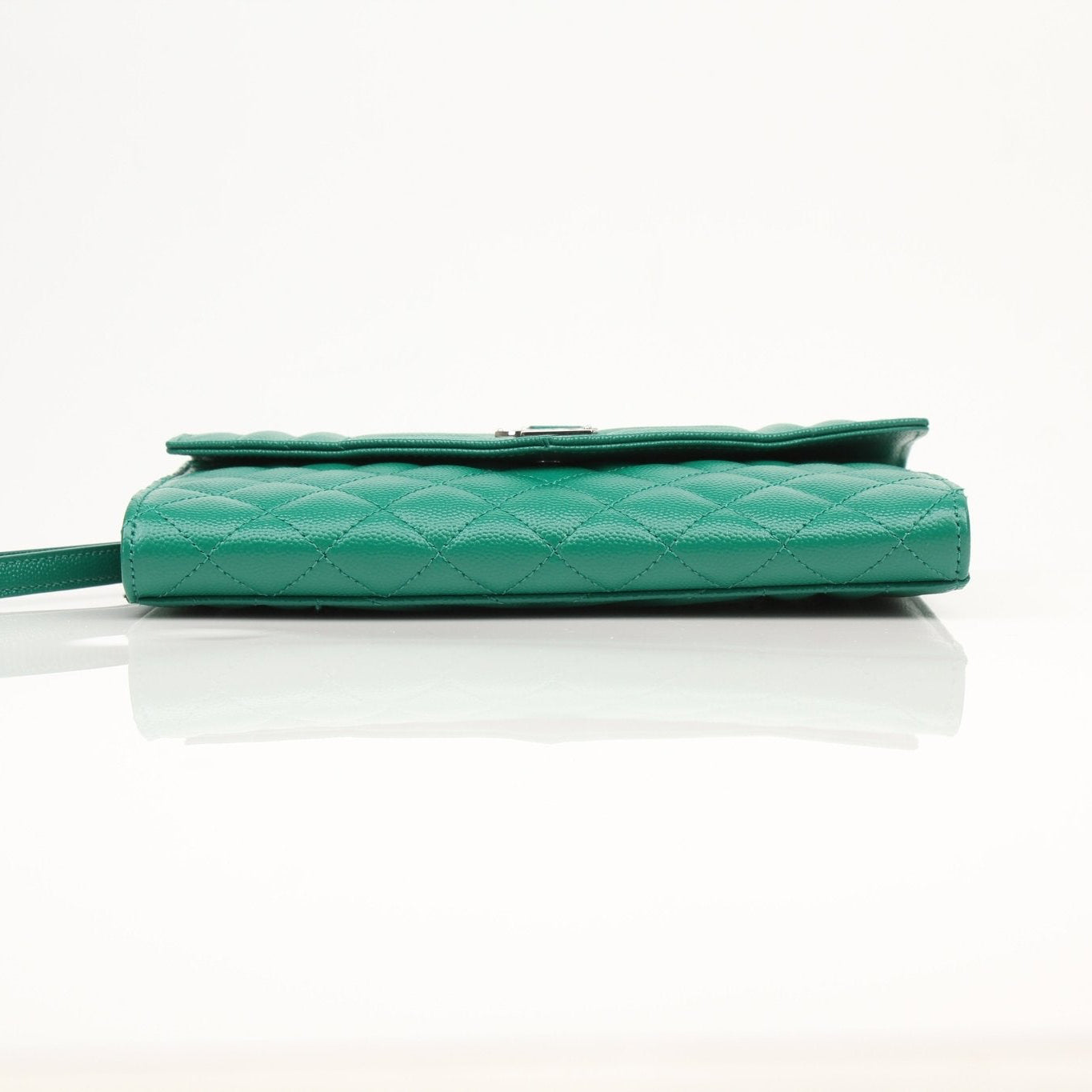 YSL green quilted leather handbag with gold accents, compact design, featuring a flap closure and textured exterior.
