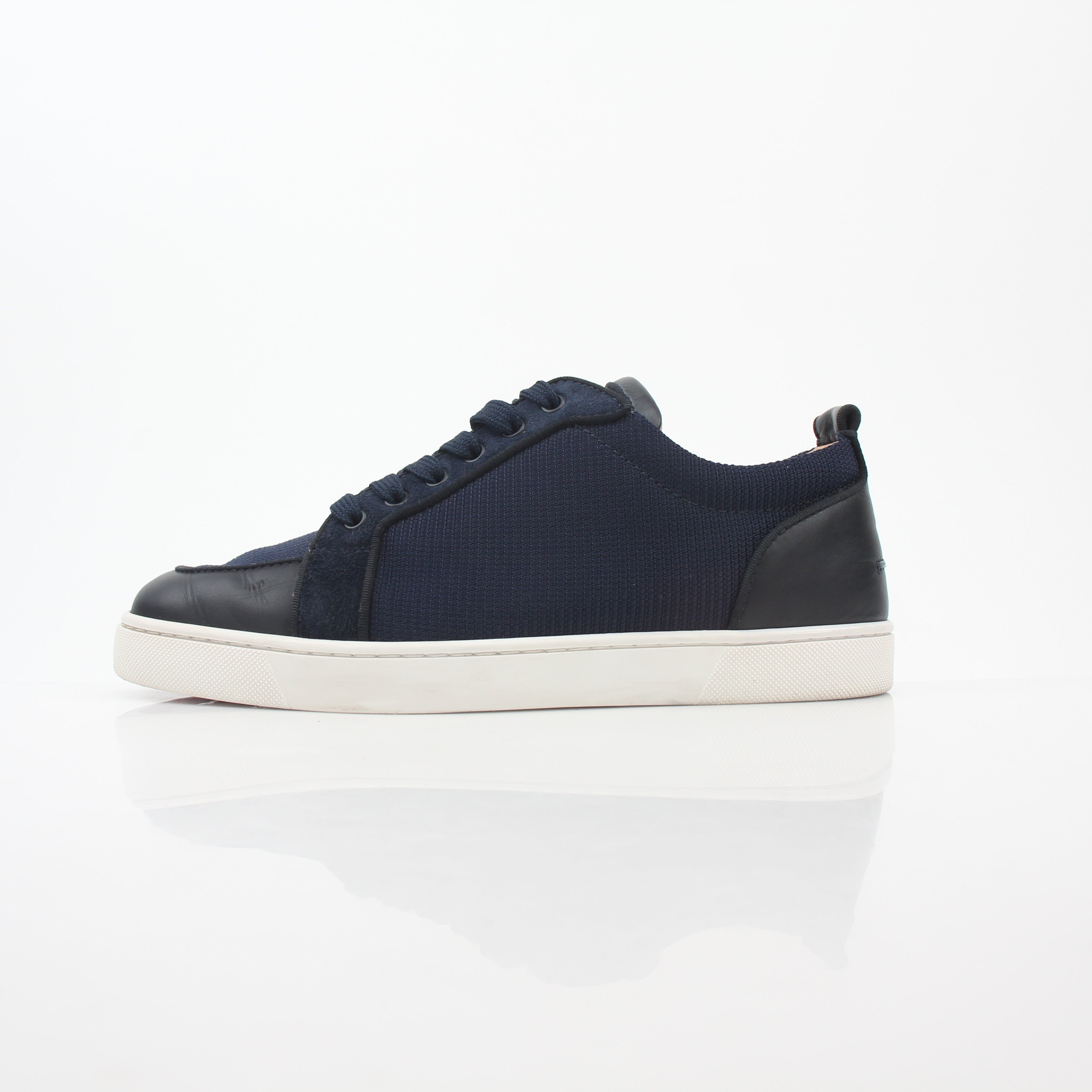 Christian Louboutin Navy Rantulow Orlato low-top sneakers with red sole and sleek design, displayed on a white background.