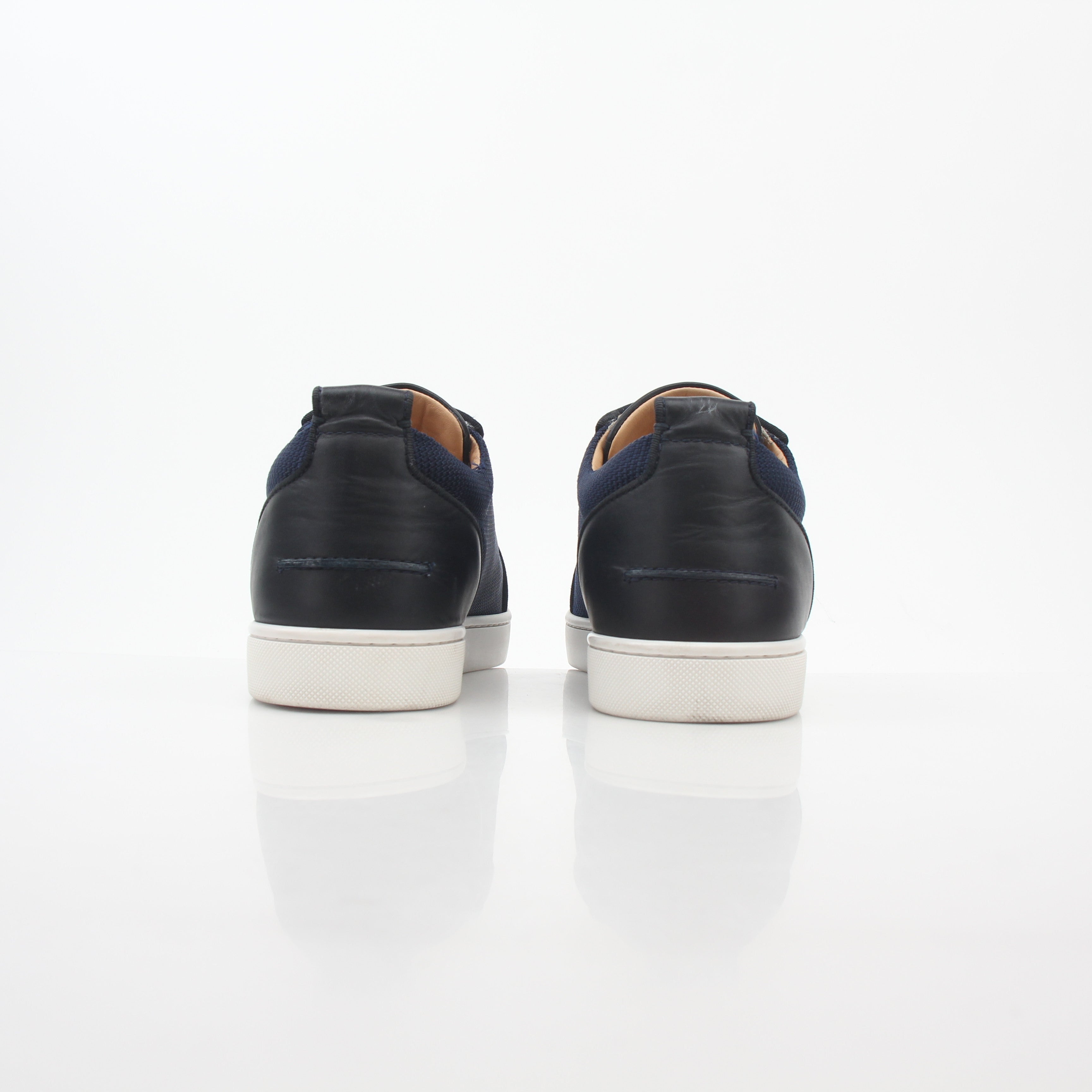 Christian Louboutin Navy Rantulow Orlato low-top sneakers with gold accents, showcasing sleek design and iconic branding.