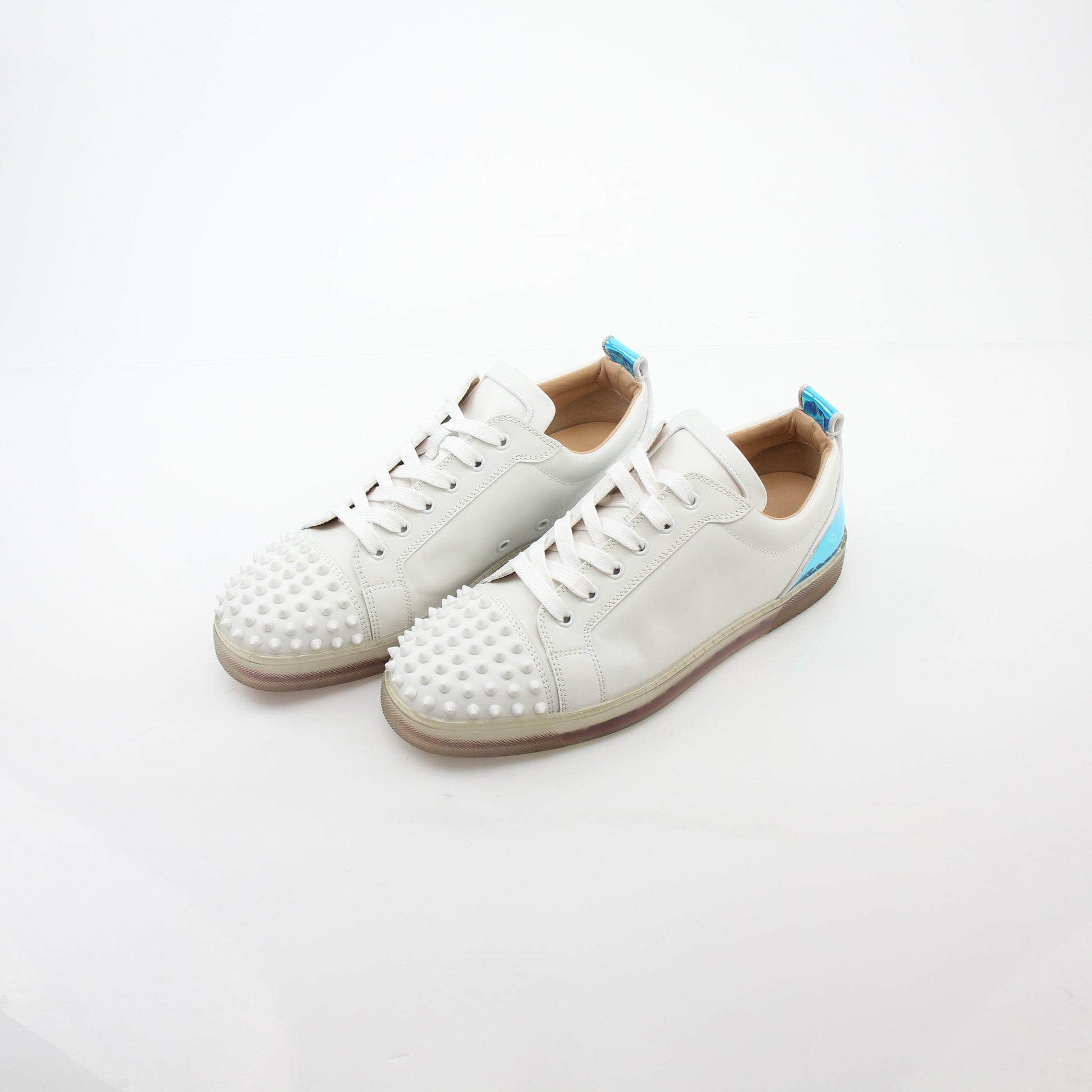 Christian Louboutin Varsijunior Spikes 2 white low-top sneakers with black accents and studded design, displayed on a plain background.