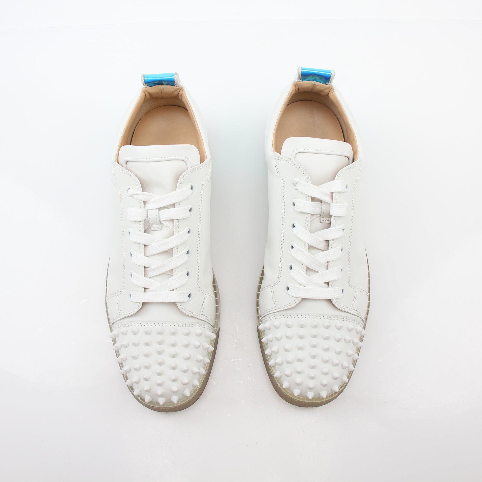 White Christian Louboutin Varsijunior Spikes 2 low-top sneakers with metallic spikes, styled with laces and a sleek shoe design.
