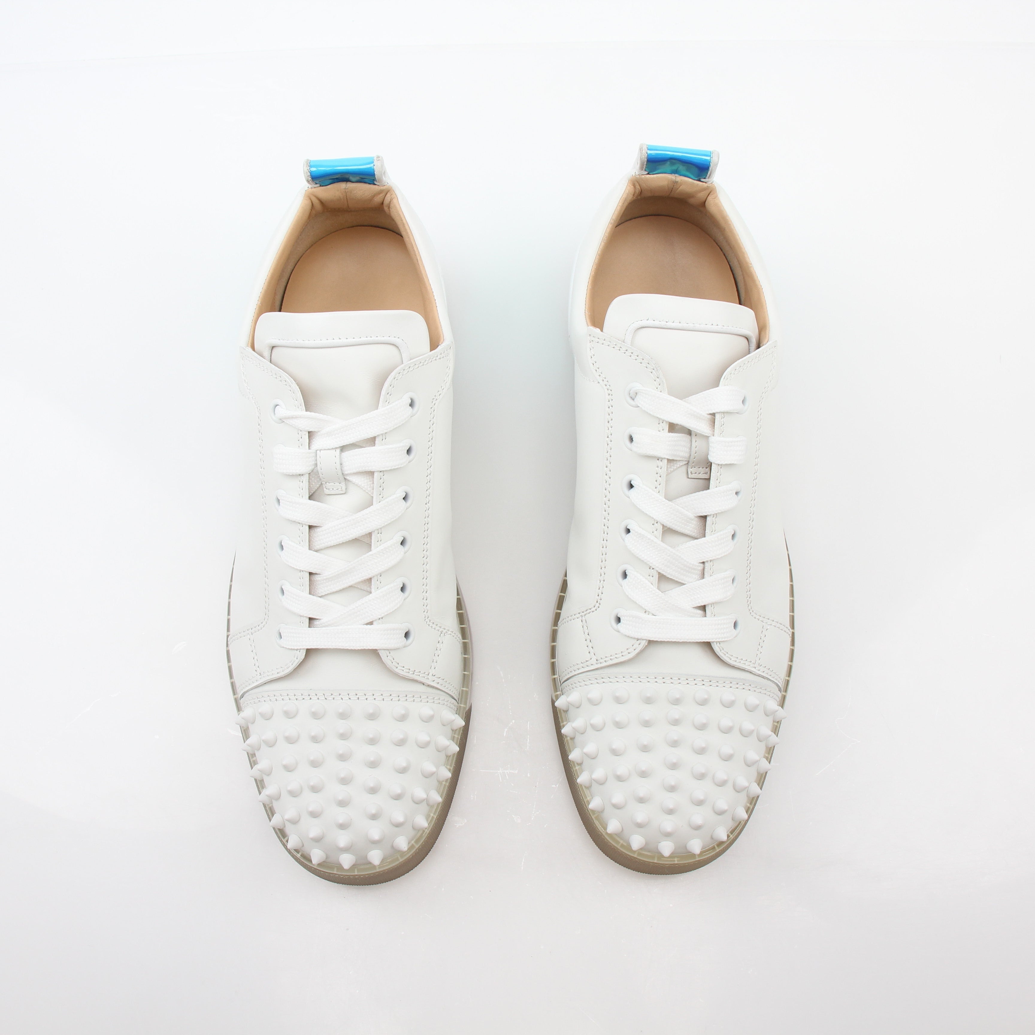 White Christian Louboutin Varsijunior Spikes 2 low-top sneakers with metallic spikes, styled with laces and a sleek shoe design.