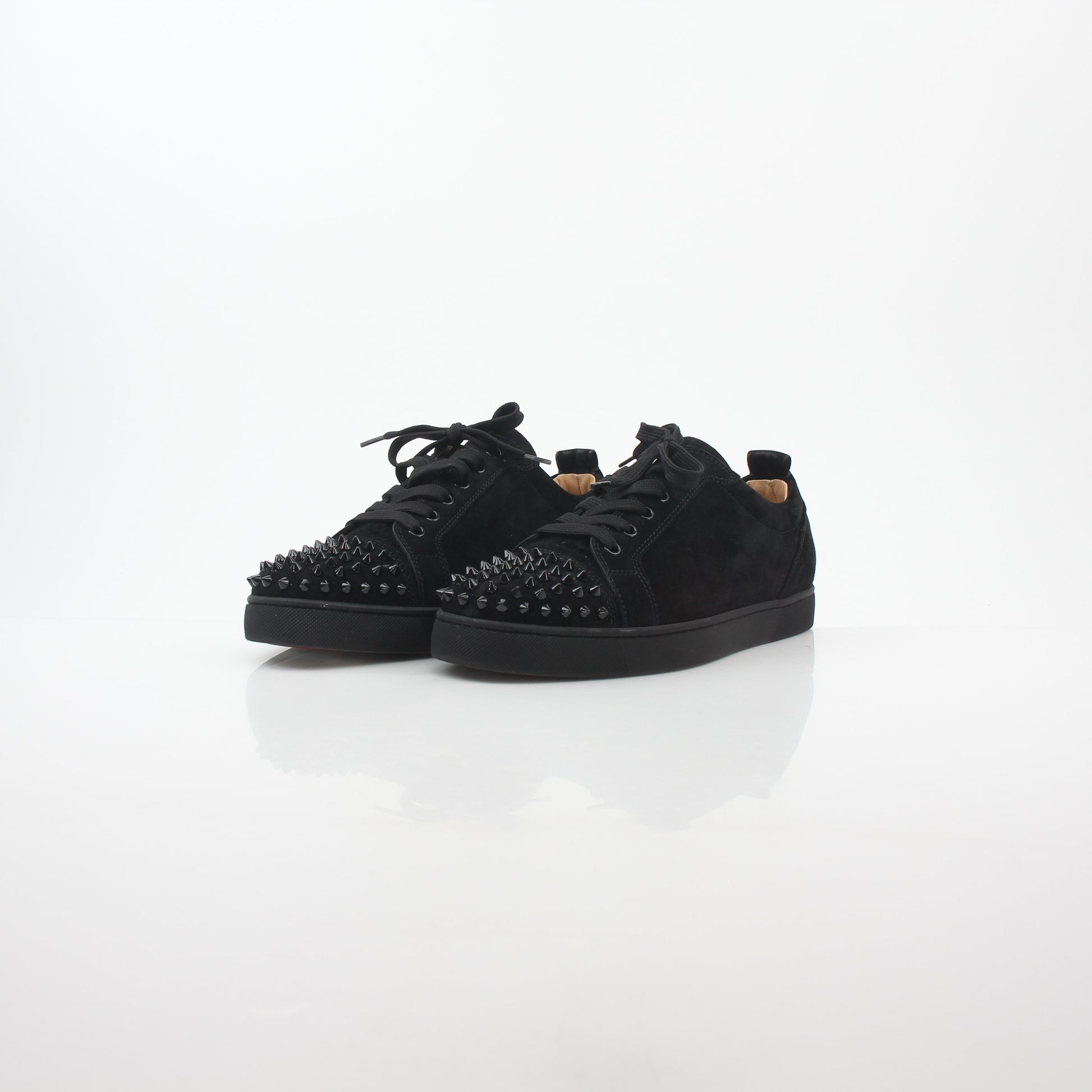 Black Christian Louboutin Louis Junior Spikes low-top sneakers with signature spikes and sleek design, shown from the side.