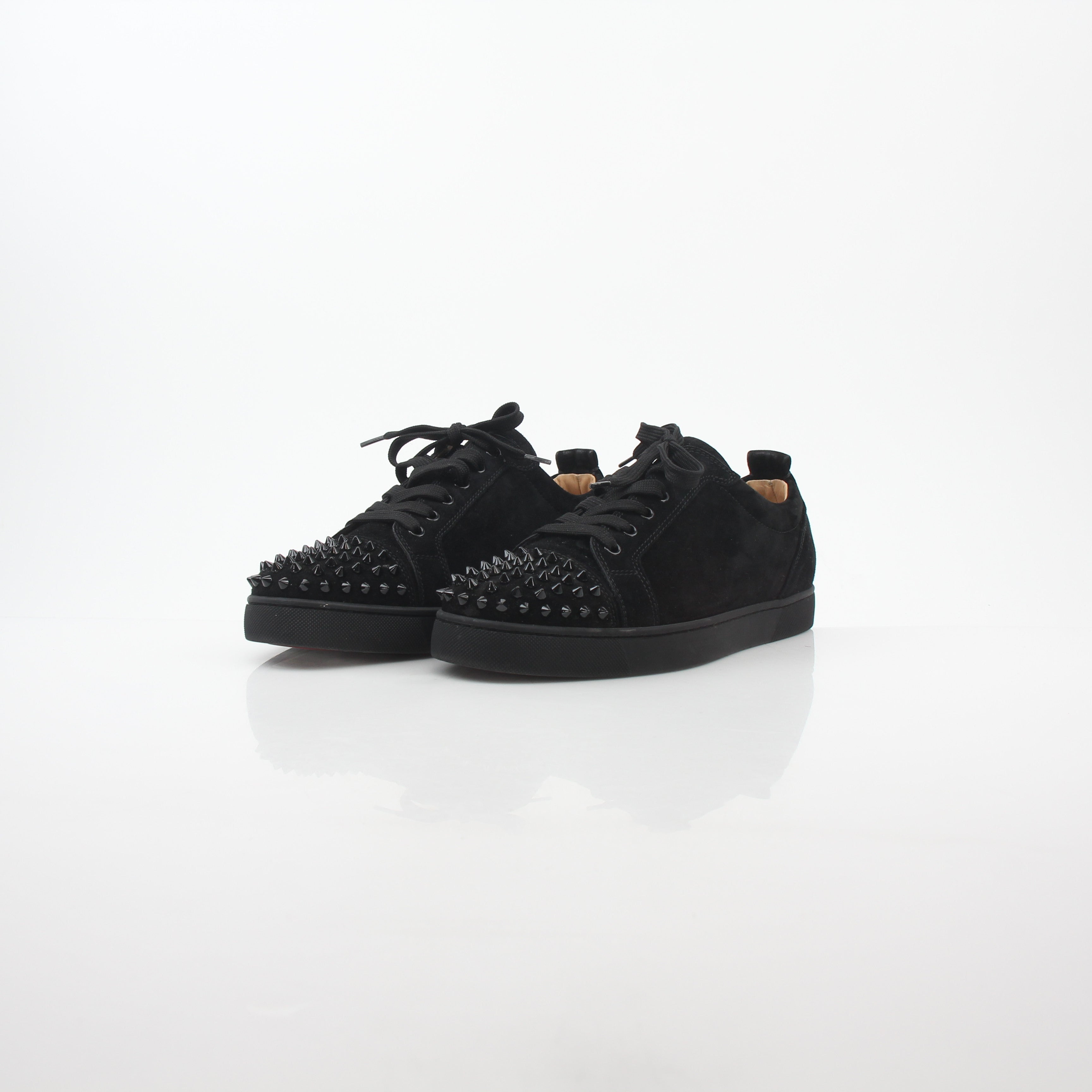 Black Christian Louboutin Louis Junior Spikes low-top sneakers with signature spikes and sleek design, shown from the side.