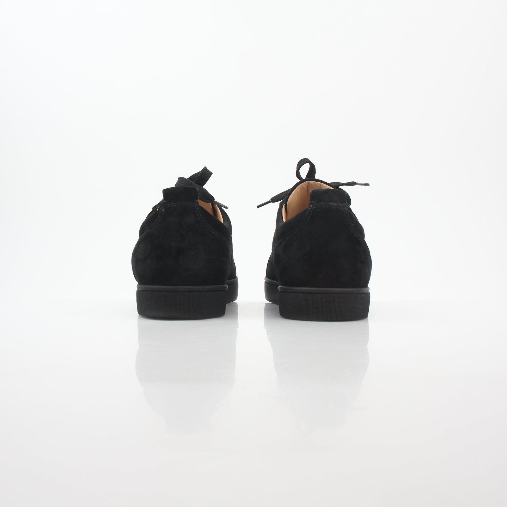 Black Christian Louboutin Louis Junior Spikes low-top sneakers with studded detailing, displayed on a white background.