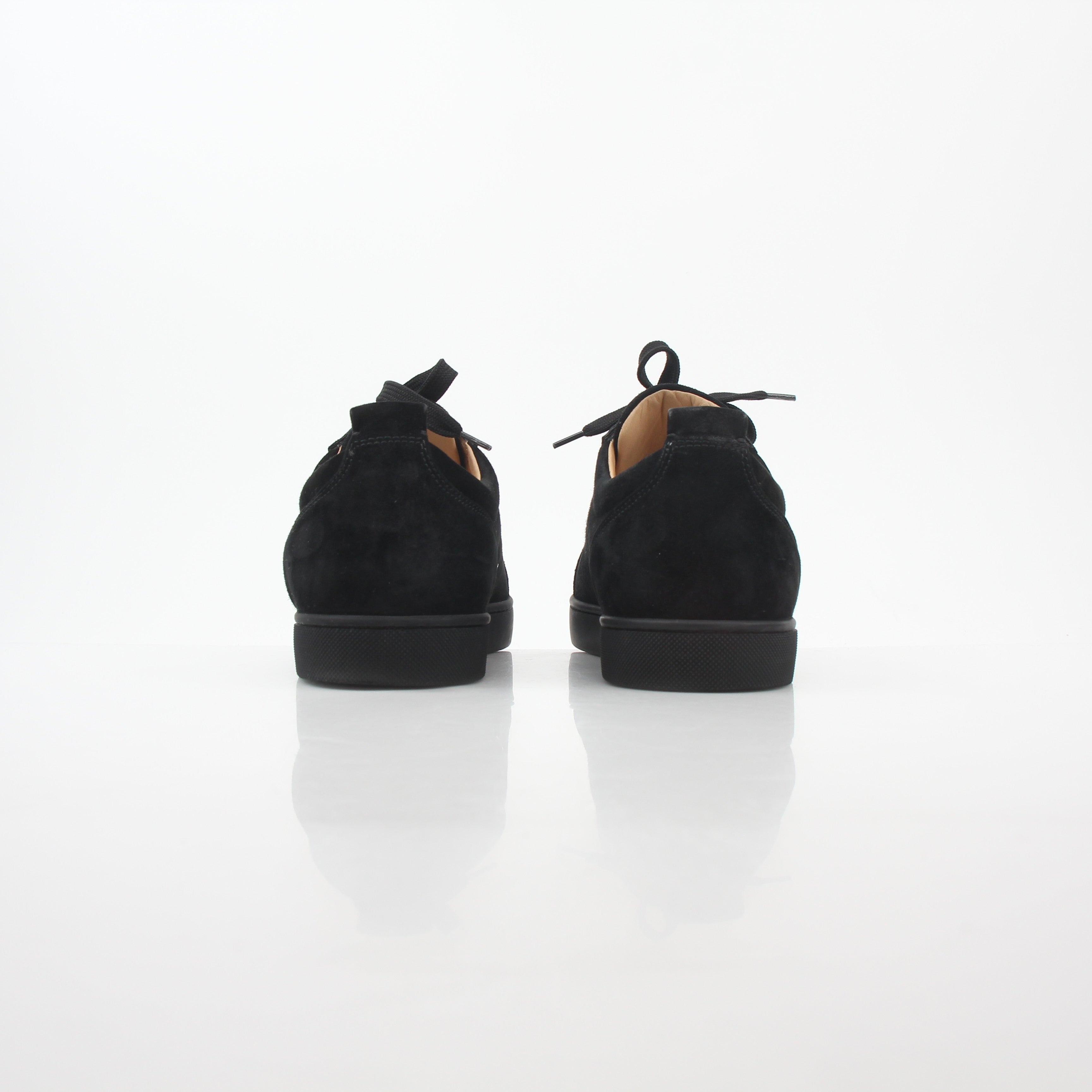 Black Christian Louboutin Louis Junior Spikes low-top sneakers with studded detailing, displayed on a white background.