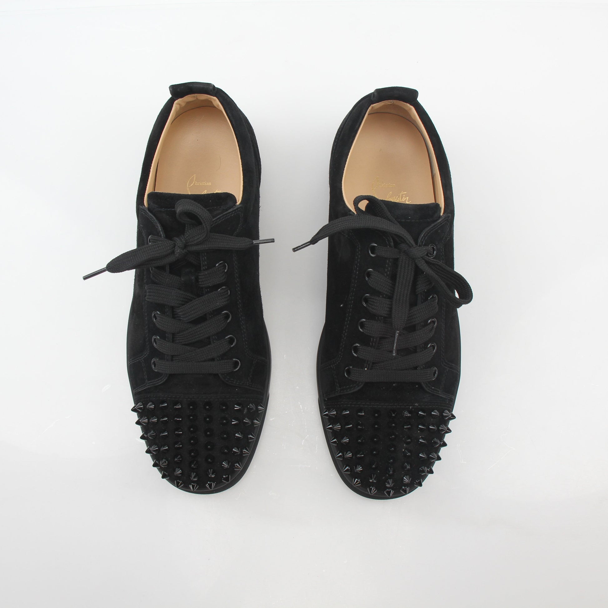 Black Christian Louboutin Louis Junior Spikes low-top sneakers with signature spikes and sleek design, displayed on a plain background.