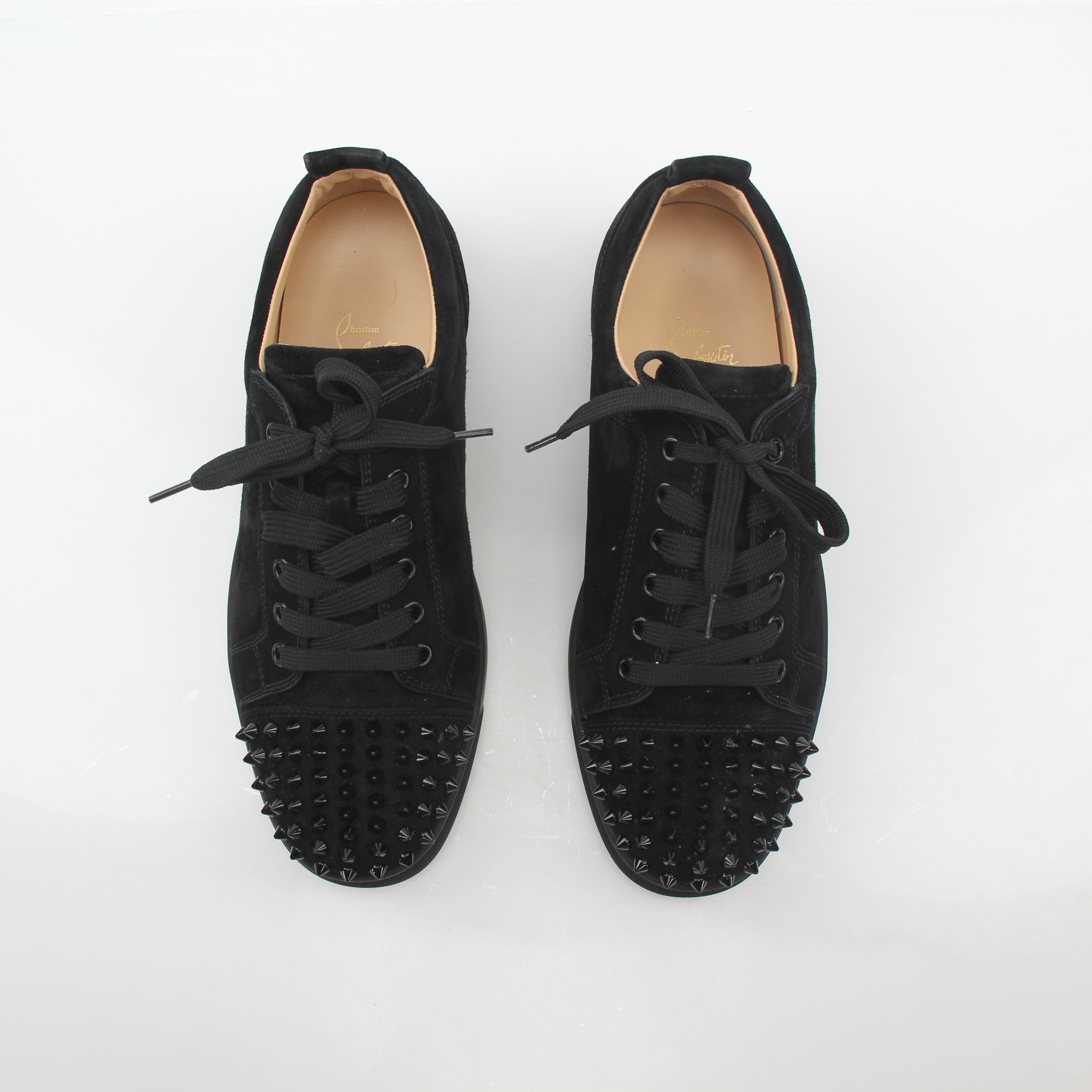 Black Christian Louboutin Louis Junior Spikes low-top sneakers with signature spikes and sleek design, displayed on a plain background.