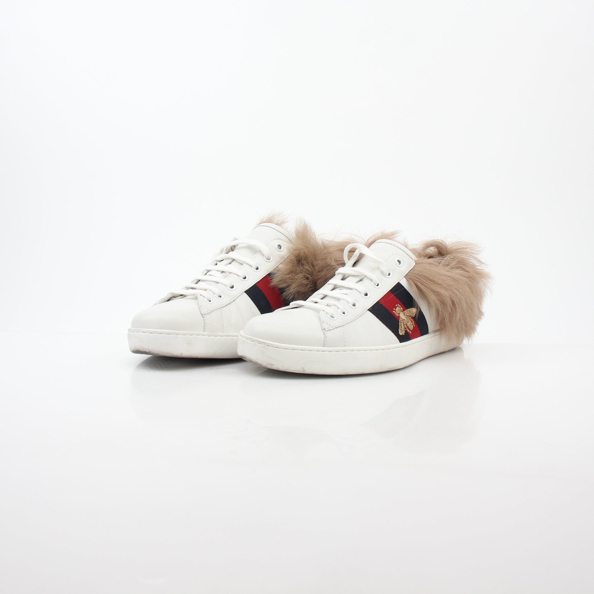 Gucci White Ace embroidered bee fur low-top sneakers with gold accents, featuring detailed embroidery and plush fur trim.