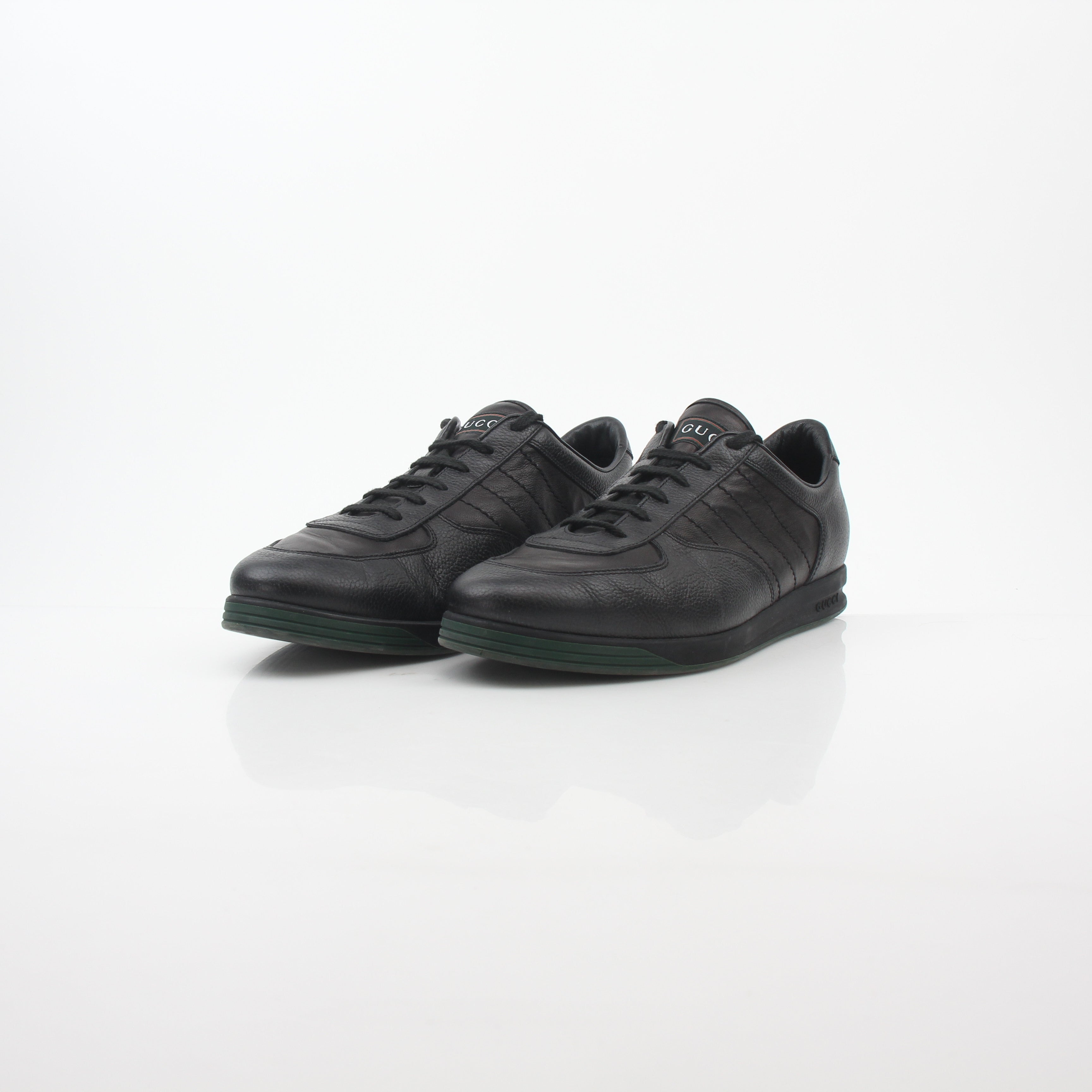 Gold & Beyond Gucci Black Tennis 1984 low-top sneakers with sleek design and signature branding, displayed on a clean background.