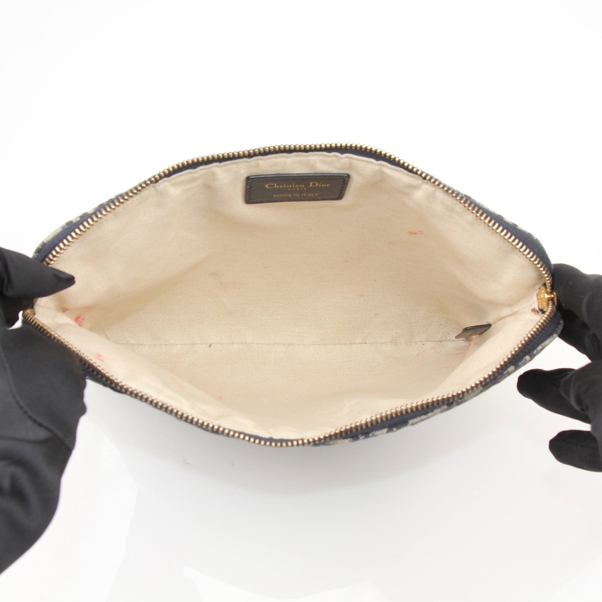 Christian Dior Oblique canvas pouch, a stylish handbag featuring Dior's signature pattern and gold accents, displayed on a neutral background.