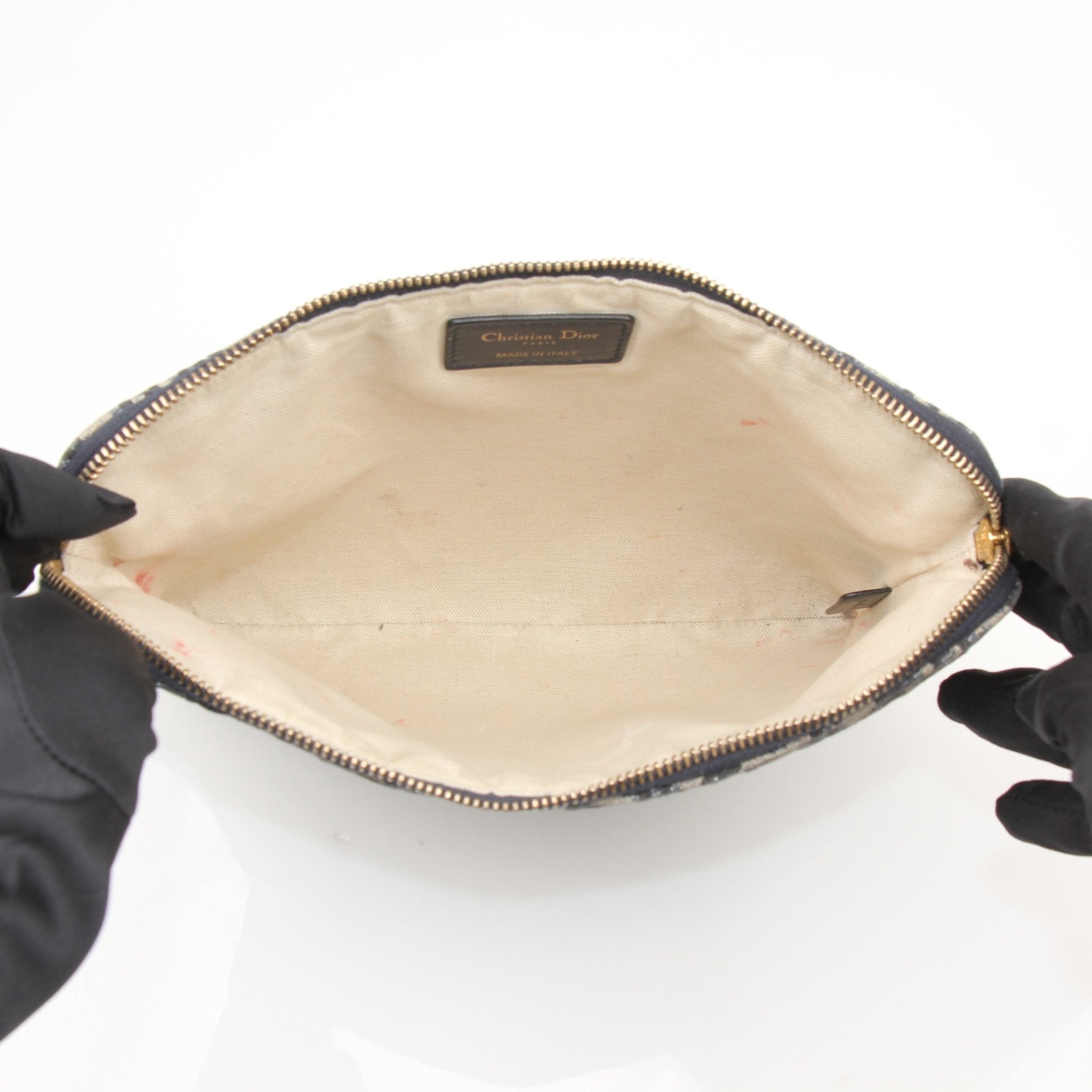 Christian Dior Oblique canvas pouch, a stylish handbag featuring Dior's signature pattern and gold accents, displayed on a neutral background.