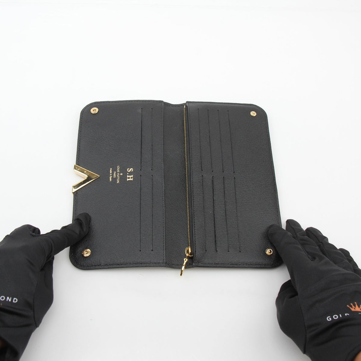 Louis Vuitton black monogram kimono wallet with gold accents, showcasing its elegant design and compact size.