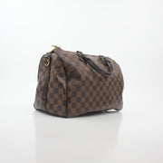 Louis Vuitton Damier Ebene Speedy Bandoulière 30 handbag with leather handles and signature checkered pattern.