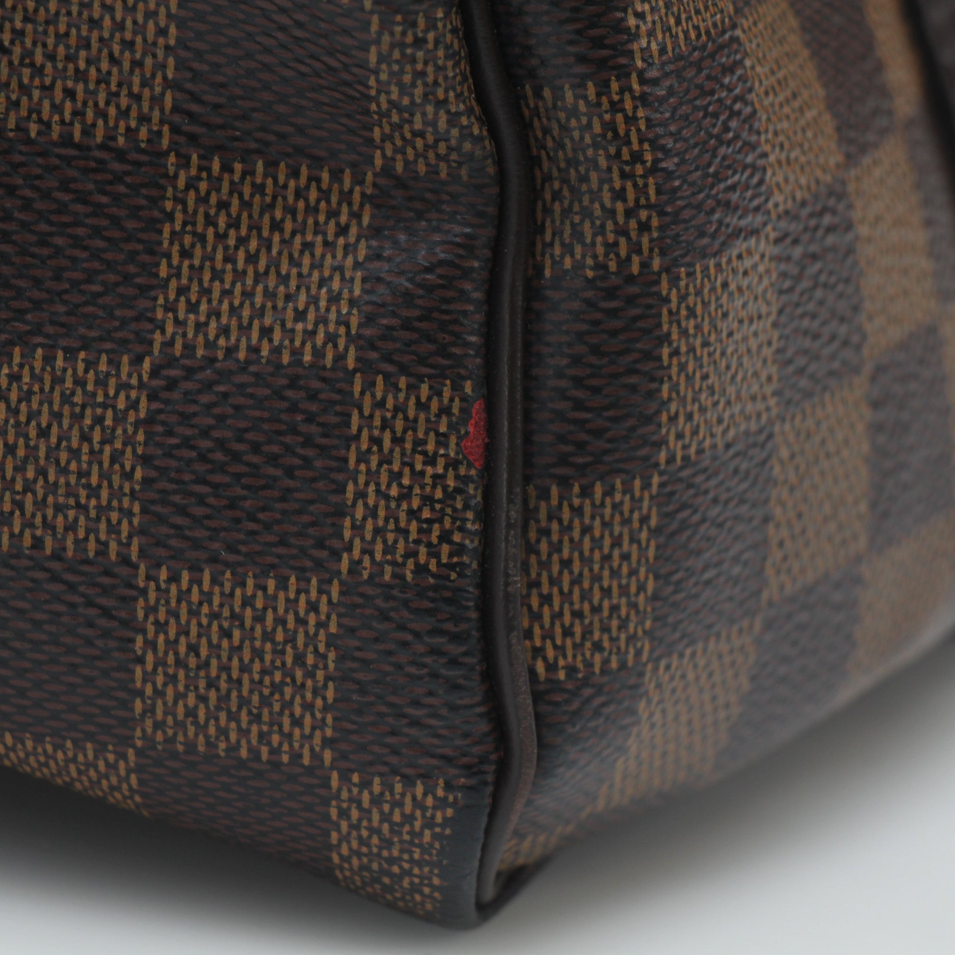 Louis Vuitton Damier Ebene Speedy Bandoulière 30 handbag with gold hardware and logo detail, showcased on a neutral background.