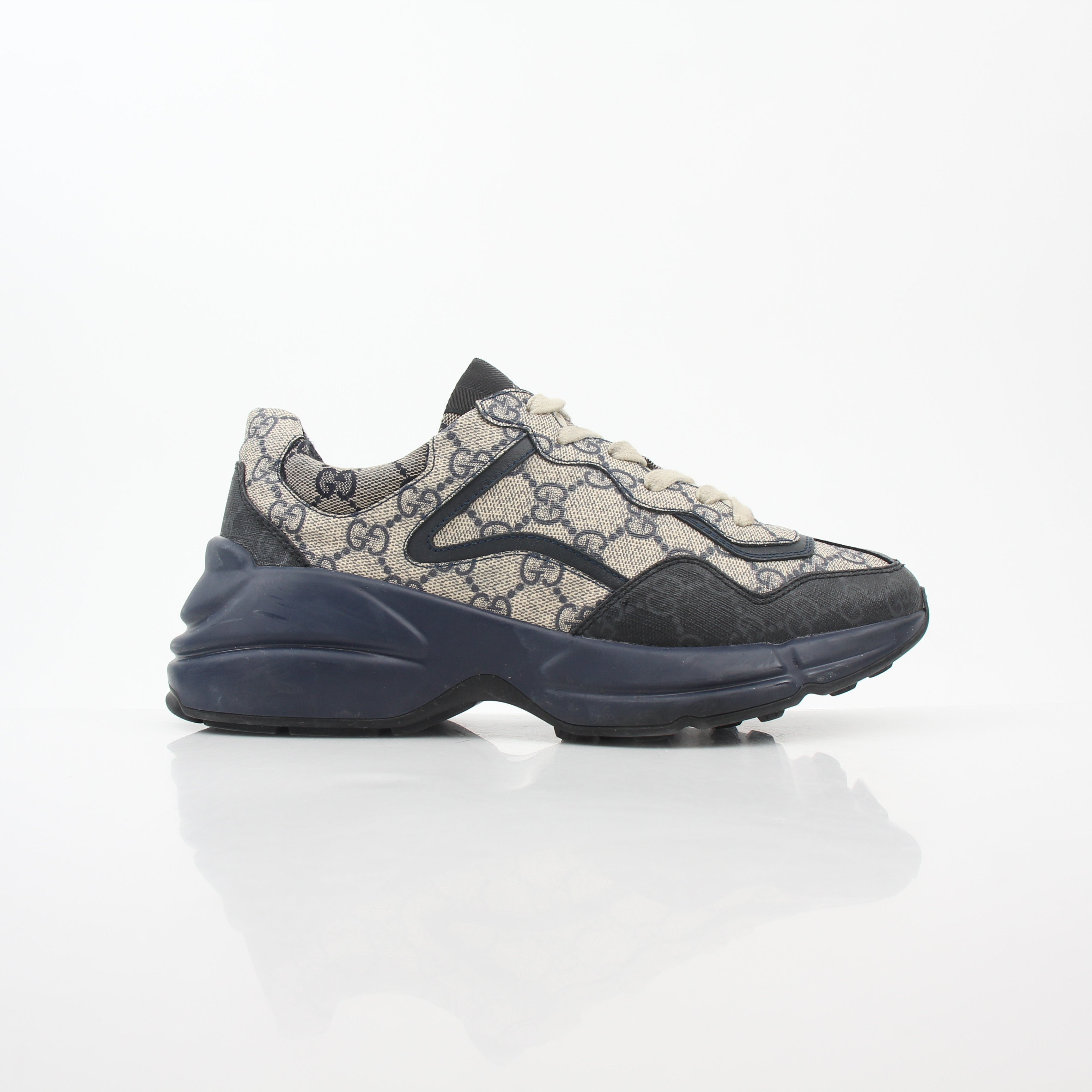 Gucci Rhyton GG Supreme Canvas Sneakers with white rubber soles and signature Gucci pattern on the canvas, displayed on a plain background.