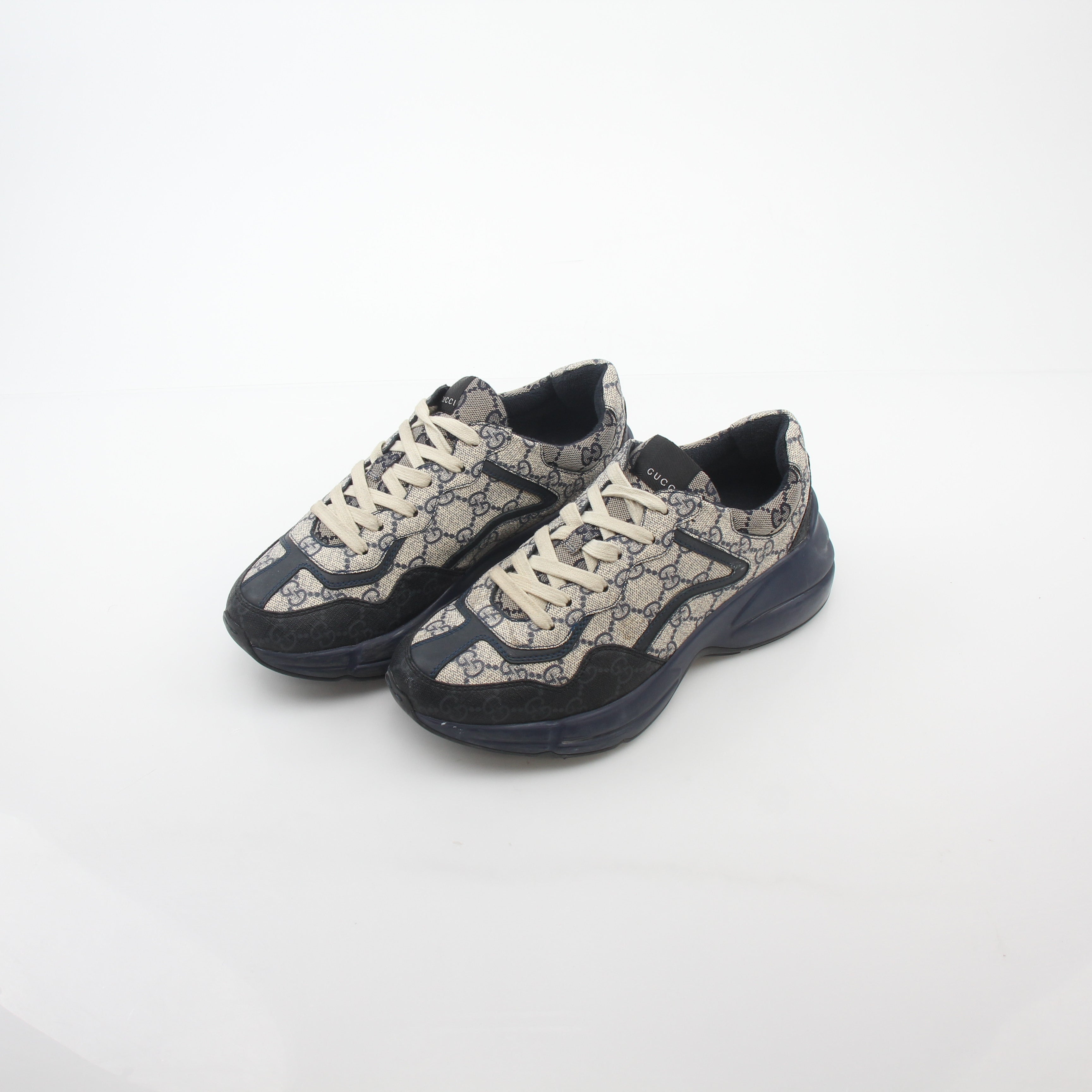 Gucci Rhyton GG Supreme Canvas Sneakers in beige and brown with rubber soles, displayed on a plain background.