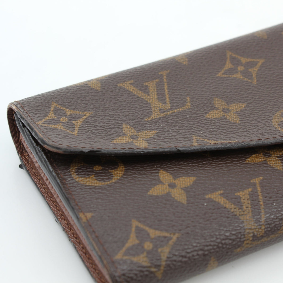 Louis Vuitton Brown Monogram Portefeuille Sarah Long Wallet with gold accents and multiple card slots, placed on a neutral background.