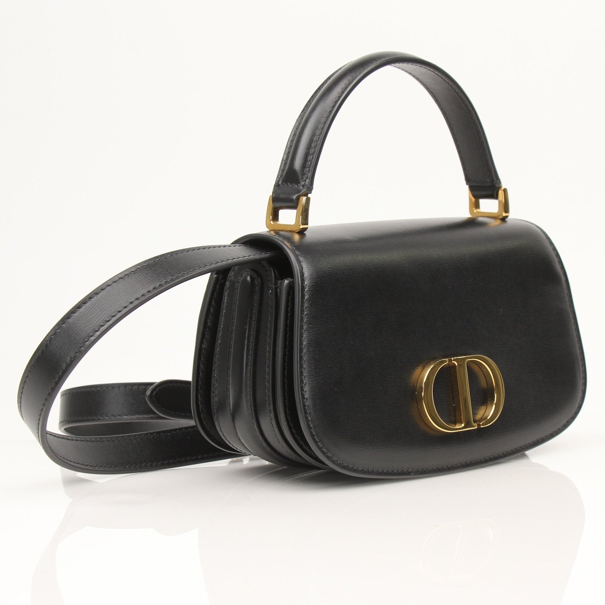 Christian Dior 30 Montaigne Avenue top handle handbag with gold hardware and structured design, displayed on a neutral background.