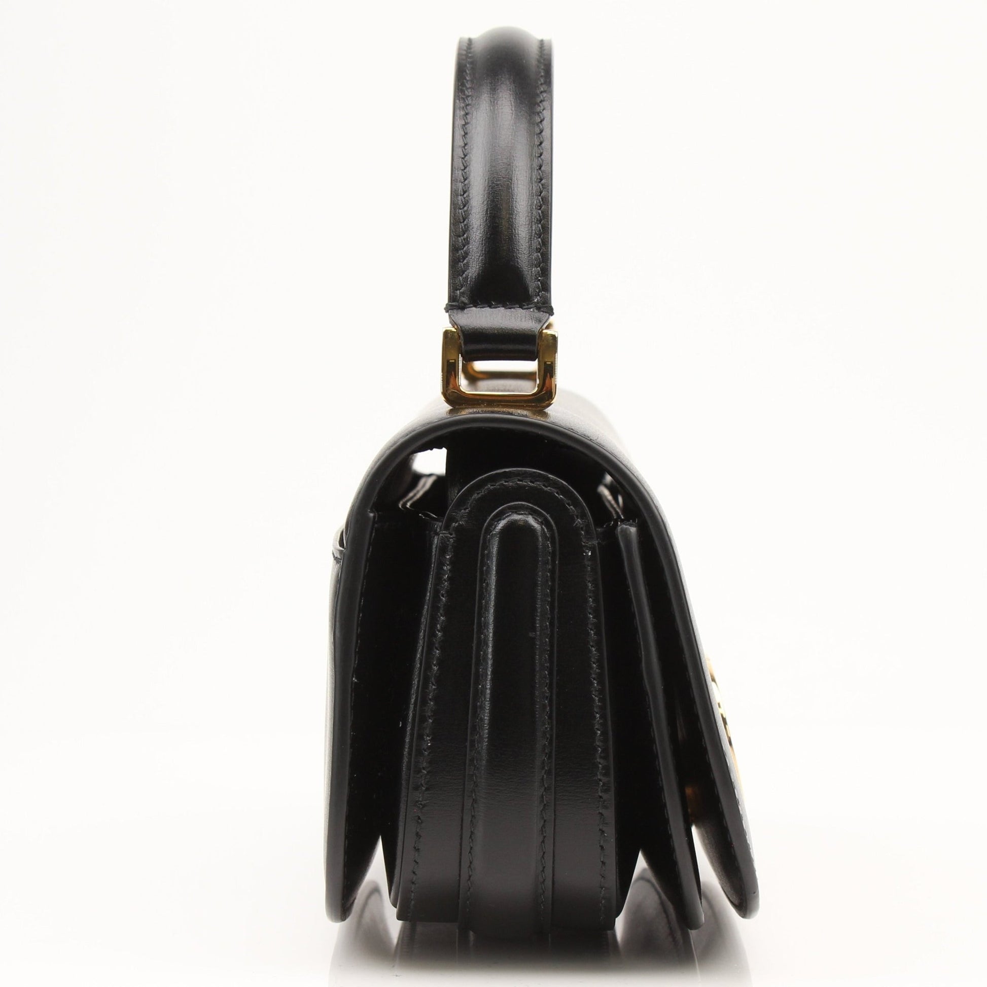 Christian Dior 30 Montaigne Avenue top handle handbag with gold hardware and structured design, displayed on a neutral background.