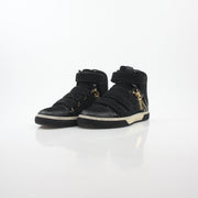 Pierre Balmain black multi-strap high-top sneakers with chunky soles and stylish design, worn by a person standing on a tiled floor.
