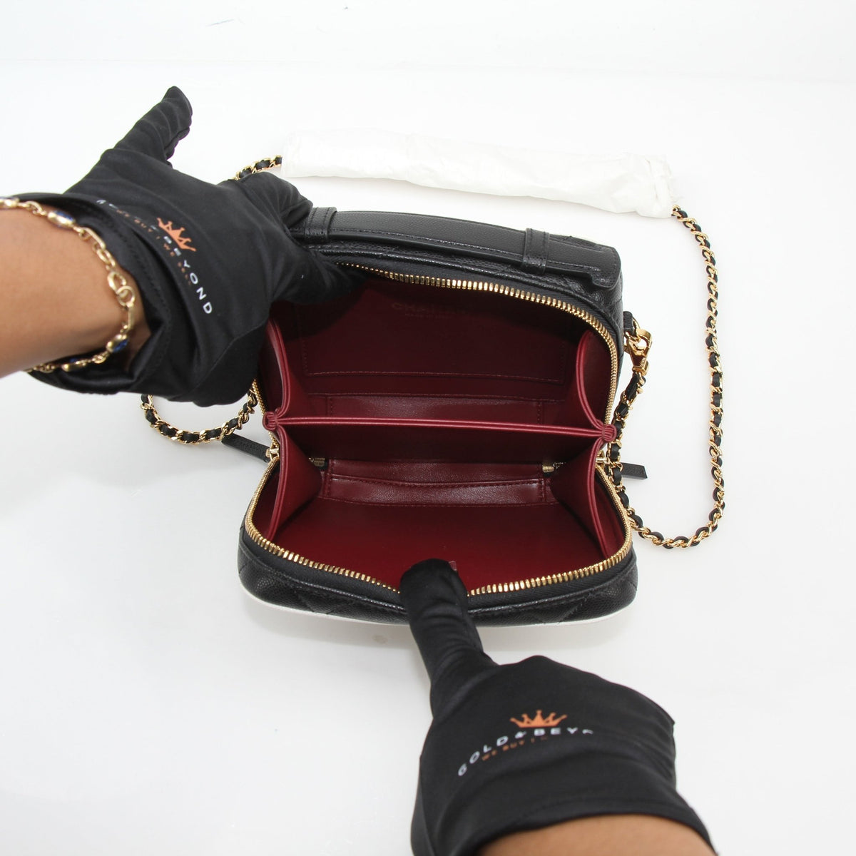 Chanel white and black small CC filigree vanity case with gold accents, featuring intricate design and compact storage.