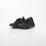 Black Adidas NMD R1 STLT Primeknit sneakers with Boost sole and white accents, displayed on a plain background.