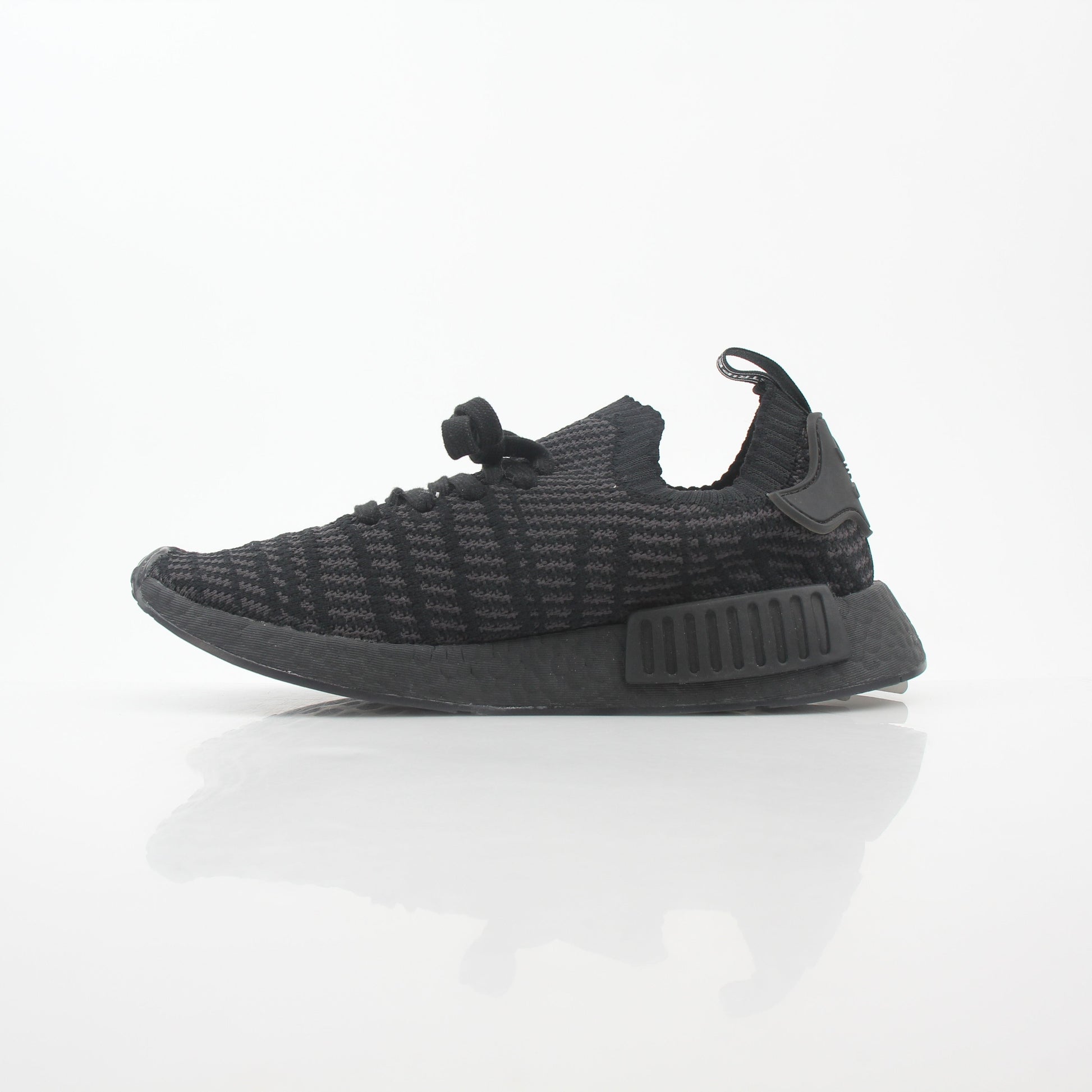 Adidas NMD R1 STLT Triple Black Primeknit sneakers in black with Boost sole and Adidas logo on the side.