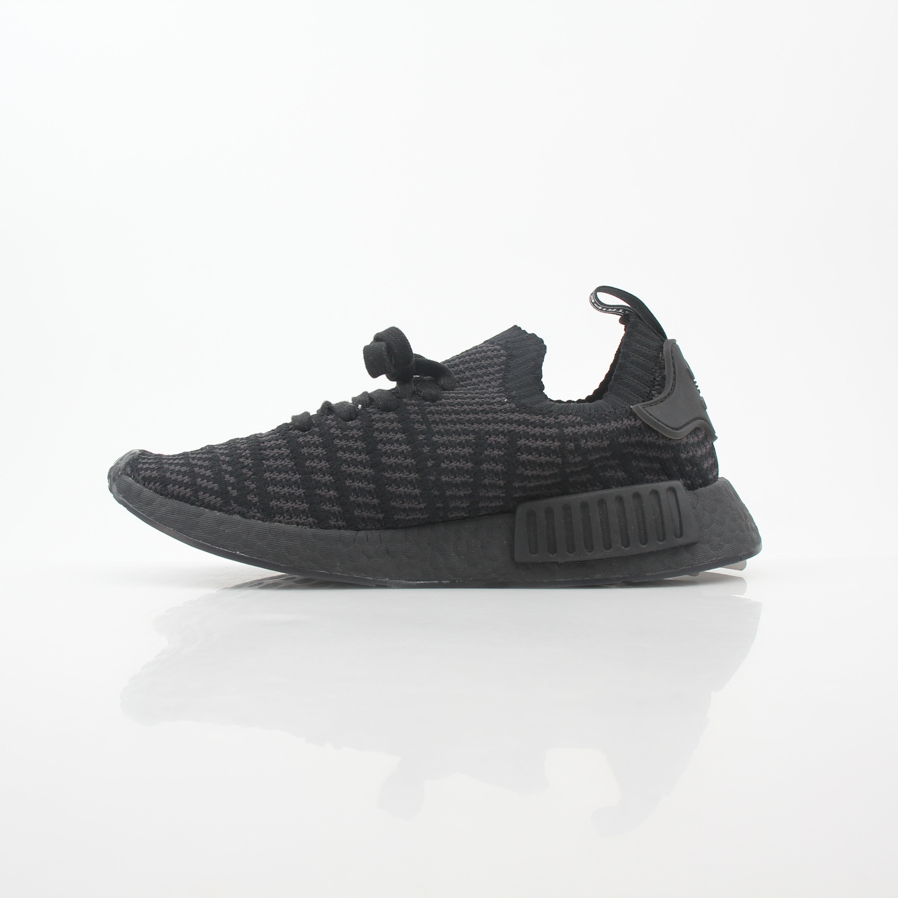 Adidas NMD R1 STLT Triple Black Primeknit sneakers in black with Boost sole and Adidas logo on the side.