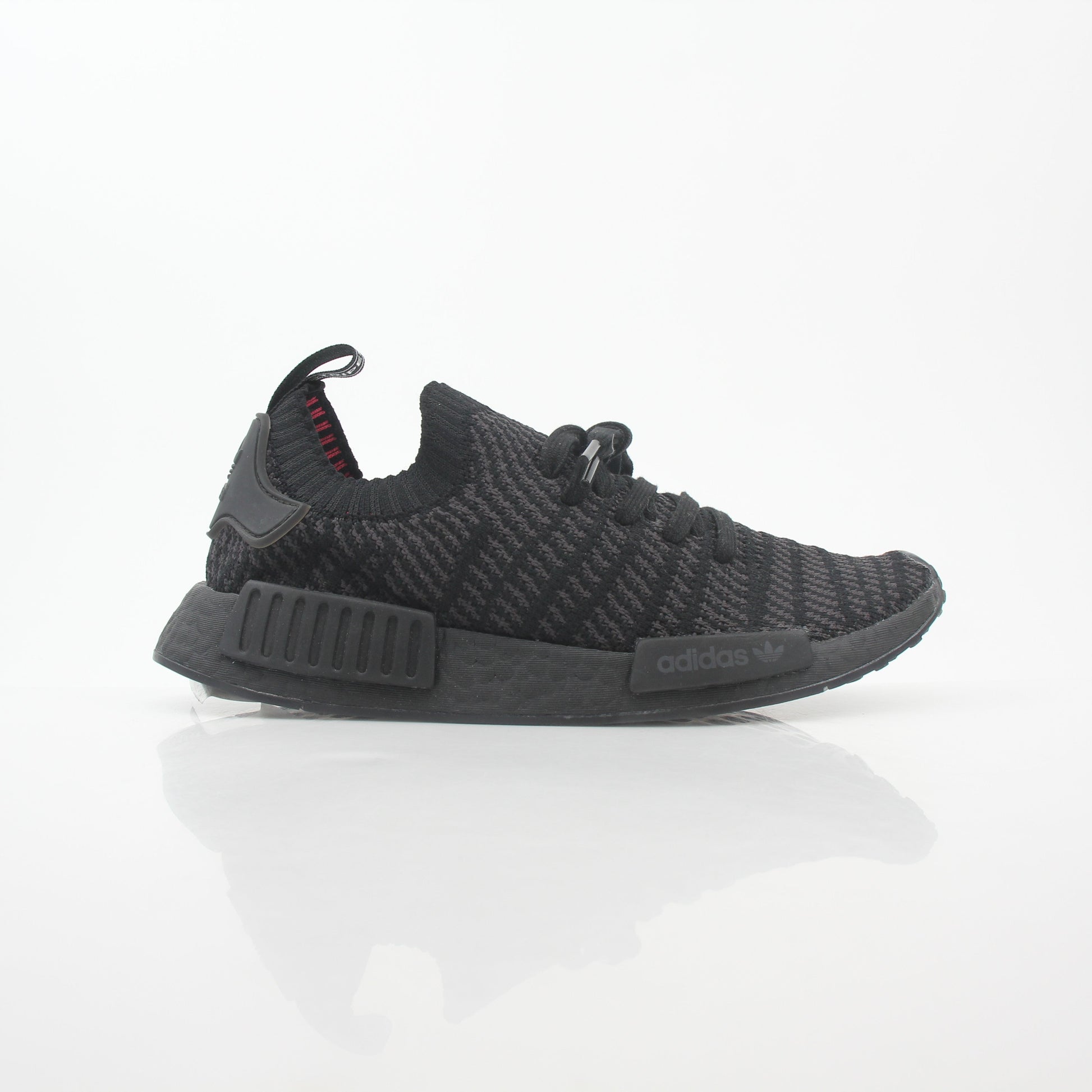Adidas NMD R1 STLT Triple Black Primeknit sneakers with black Boost midsole and sleek design, displayed on a white background.