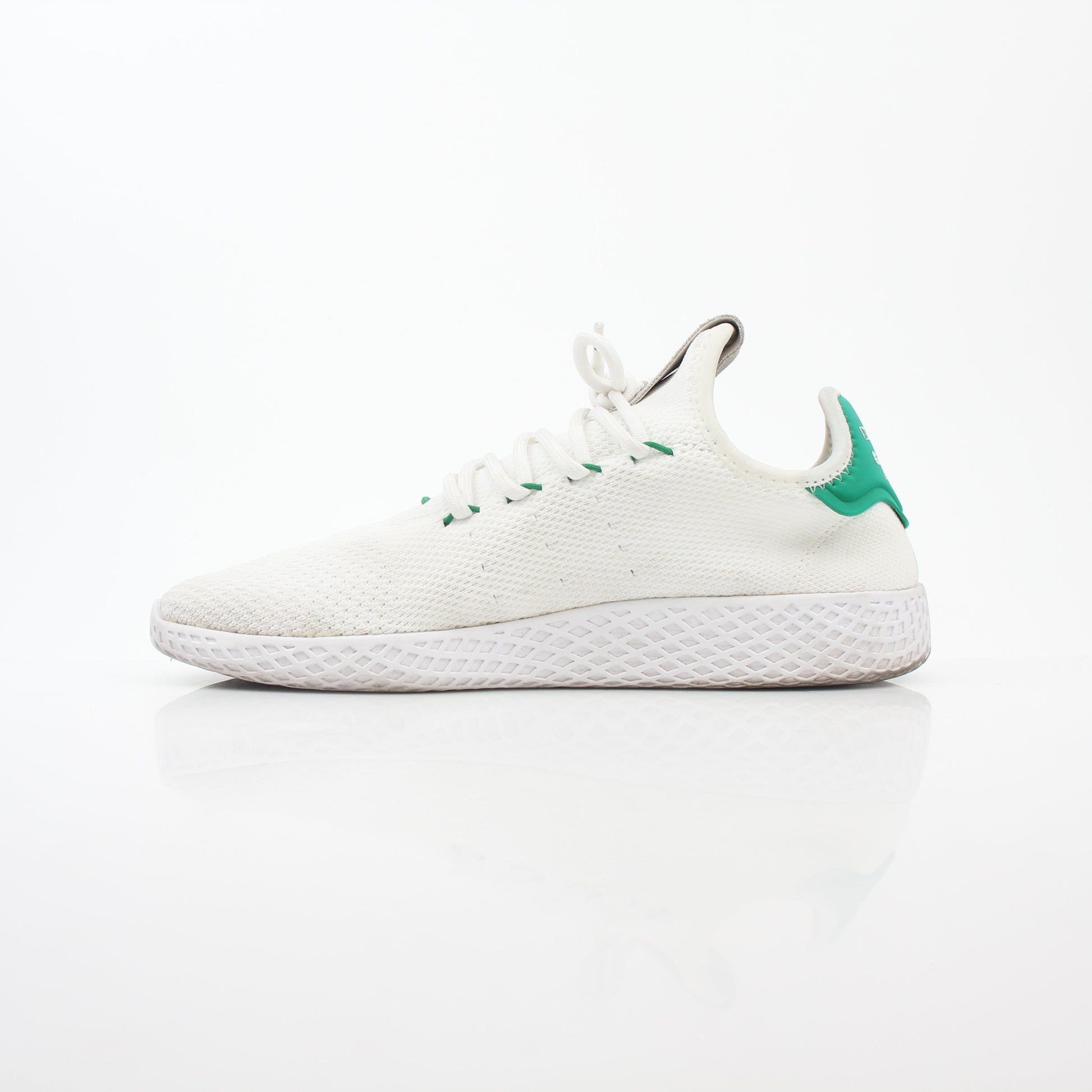 White and green Adidas x Pharrell Williams Tennis Hu sneakers with sleek design and sporty details, displayed on a plain background.