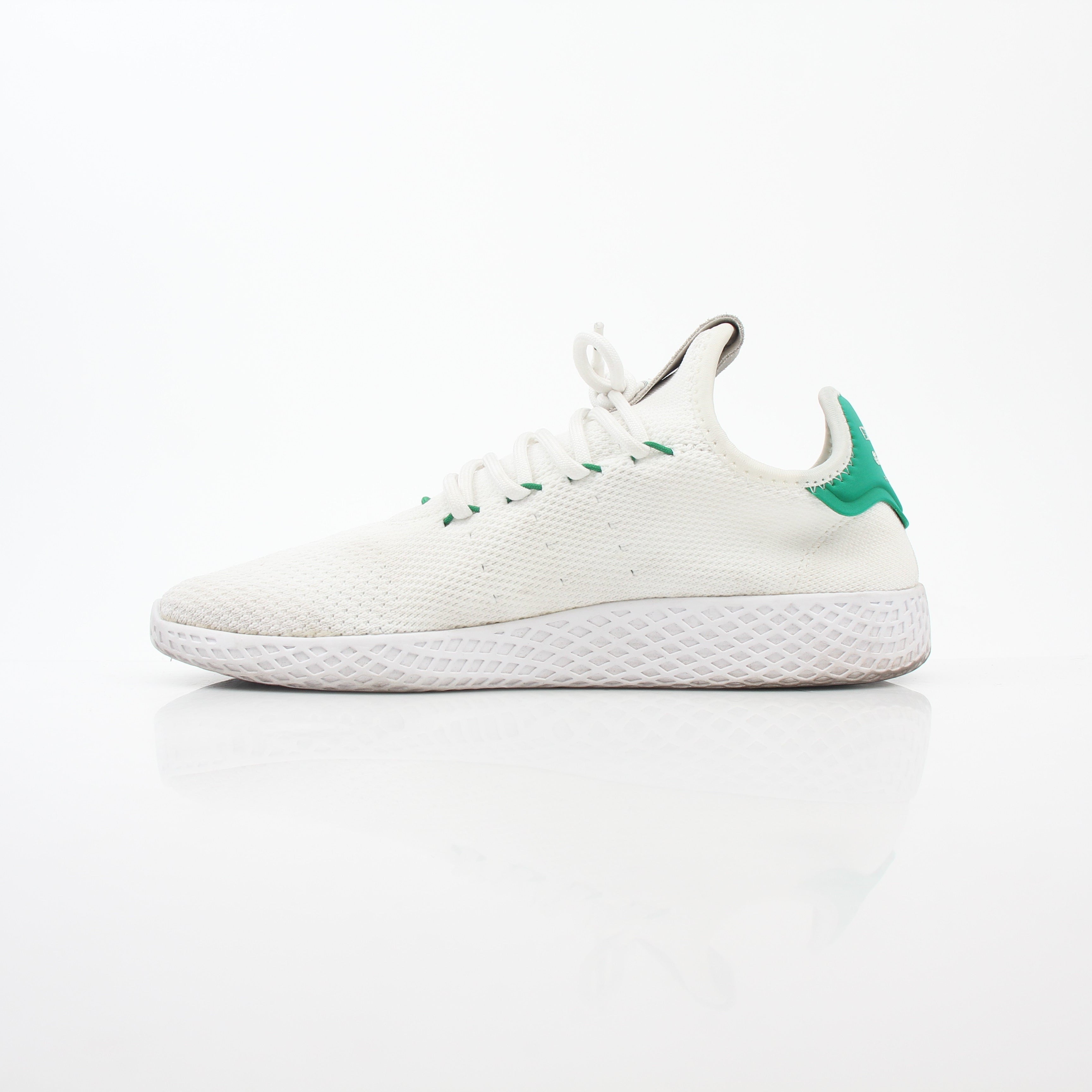 White and green Adidas x Pharrell Williams Tennis Hu sneakers with sleek design and sporty details, displayed on a plain background.