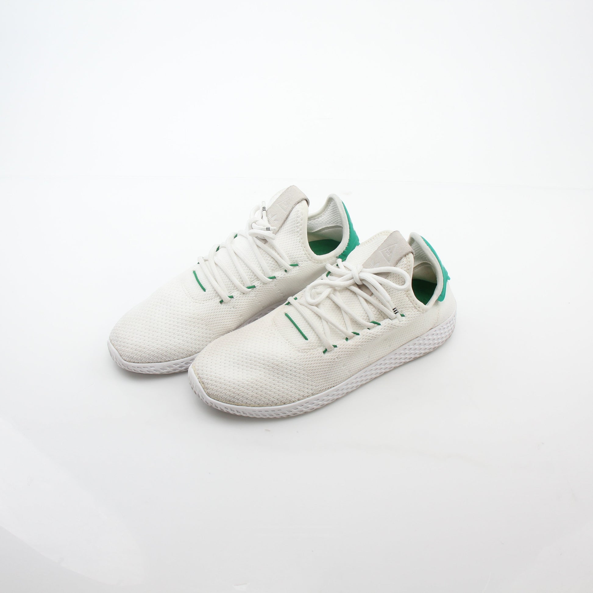 Adidas x Pharrell Williams Tennis Hu white and green sneakers with sleek design and sporty look, displayed on a plain background.
