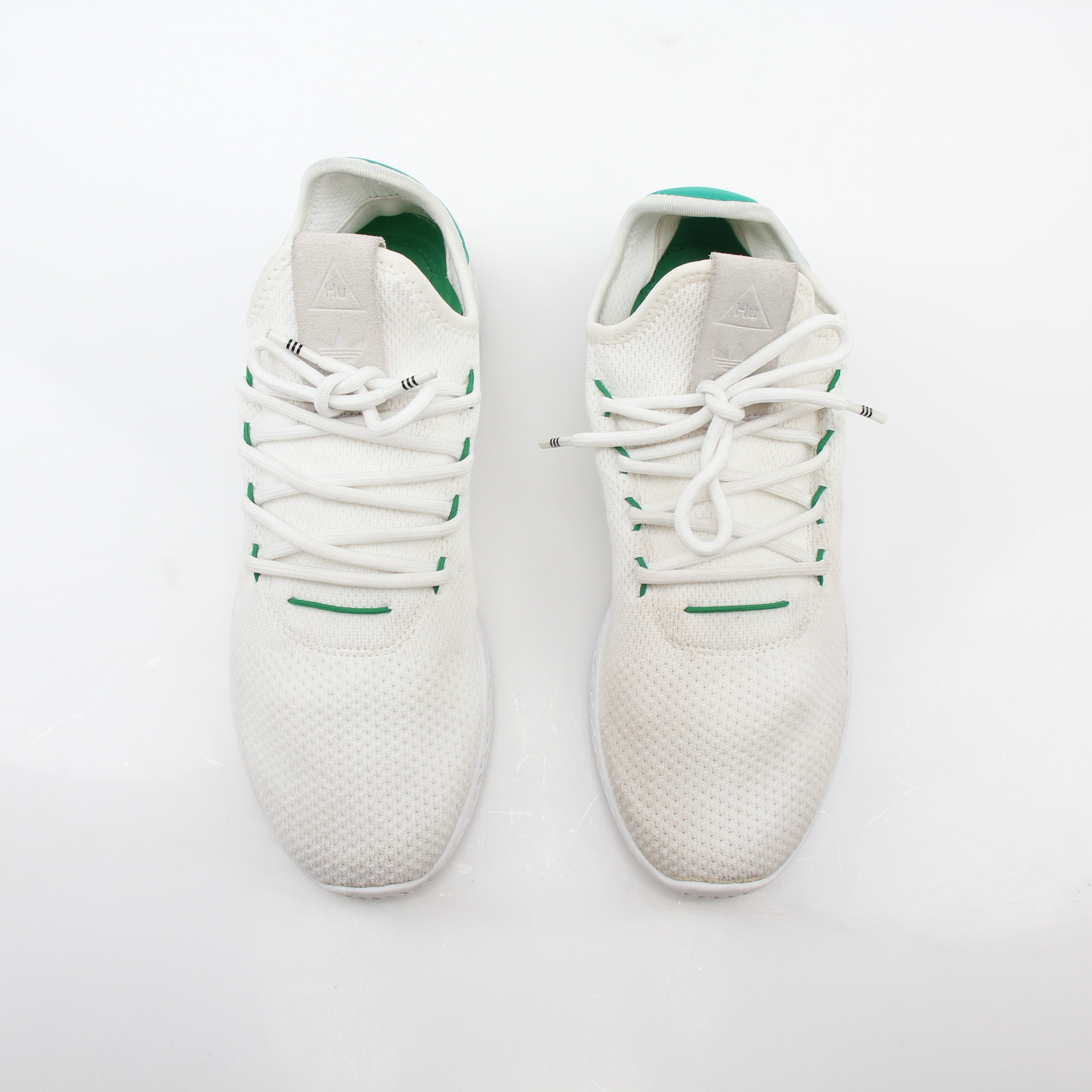 White and green Adidas x Pharrell Williams Tennis Hu sneakers with sporty design and comfortable fit.