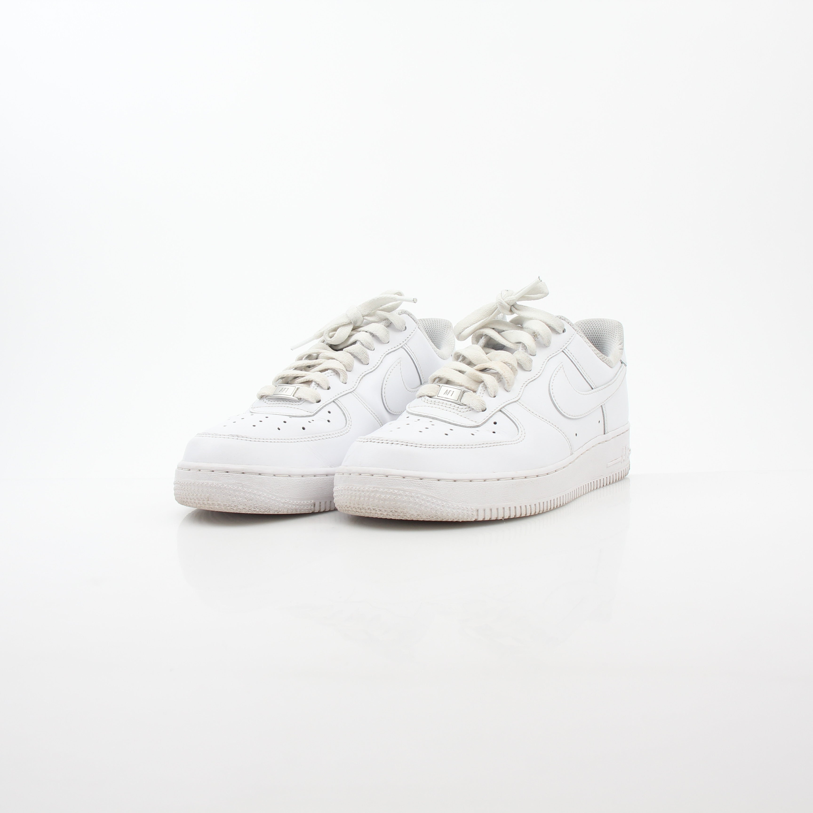 Nike White Air Force 1 ’07 Low sneakers in white leather with Nike branding and low-top design, displayed on a plain background.