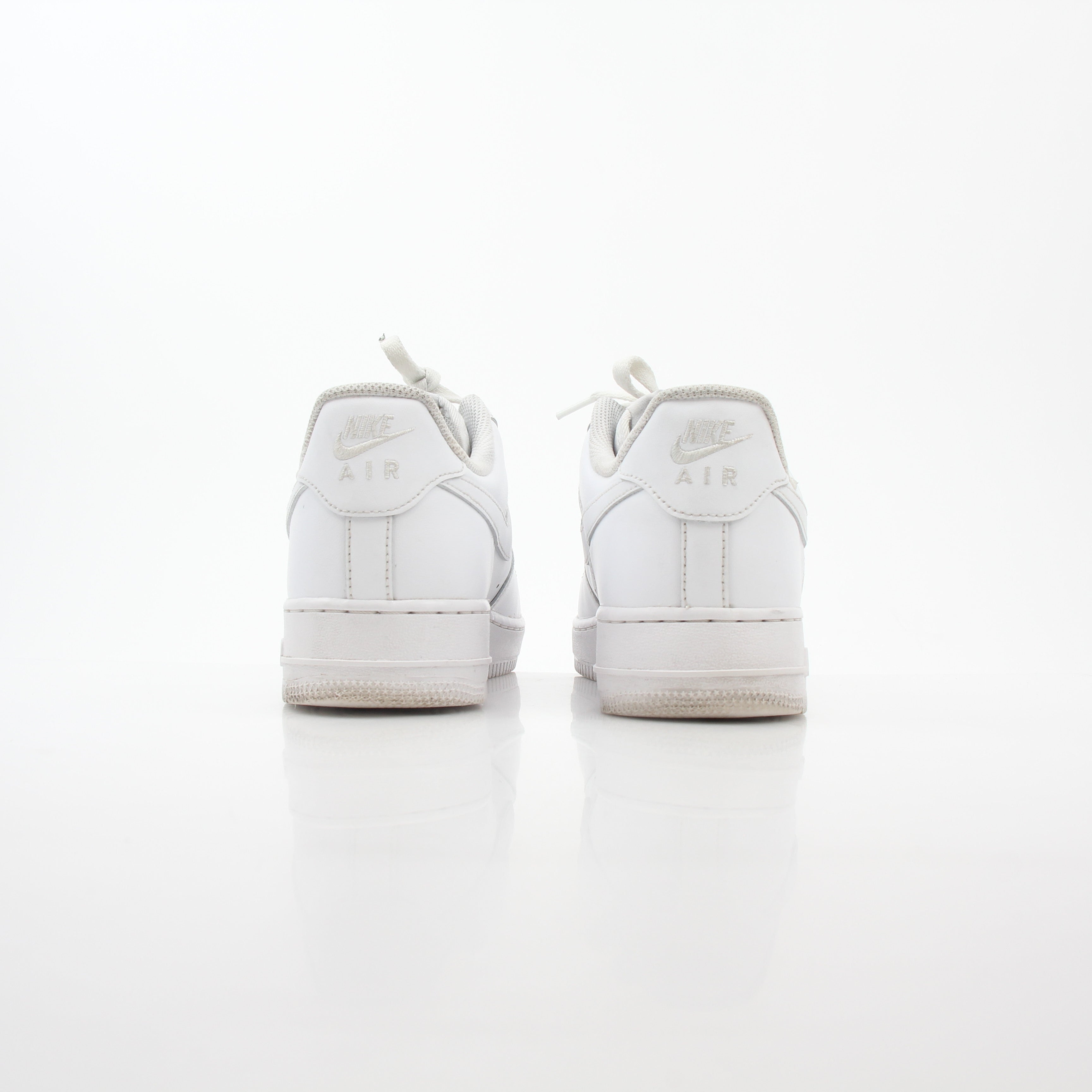 White Nike Air Force 1 ’07 Low sneakers with gold accents, shown from a side angle, featuring classic design and white laces.