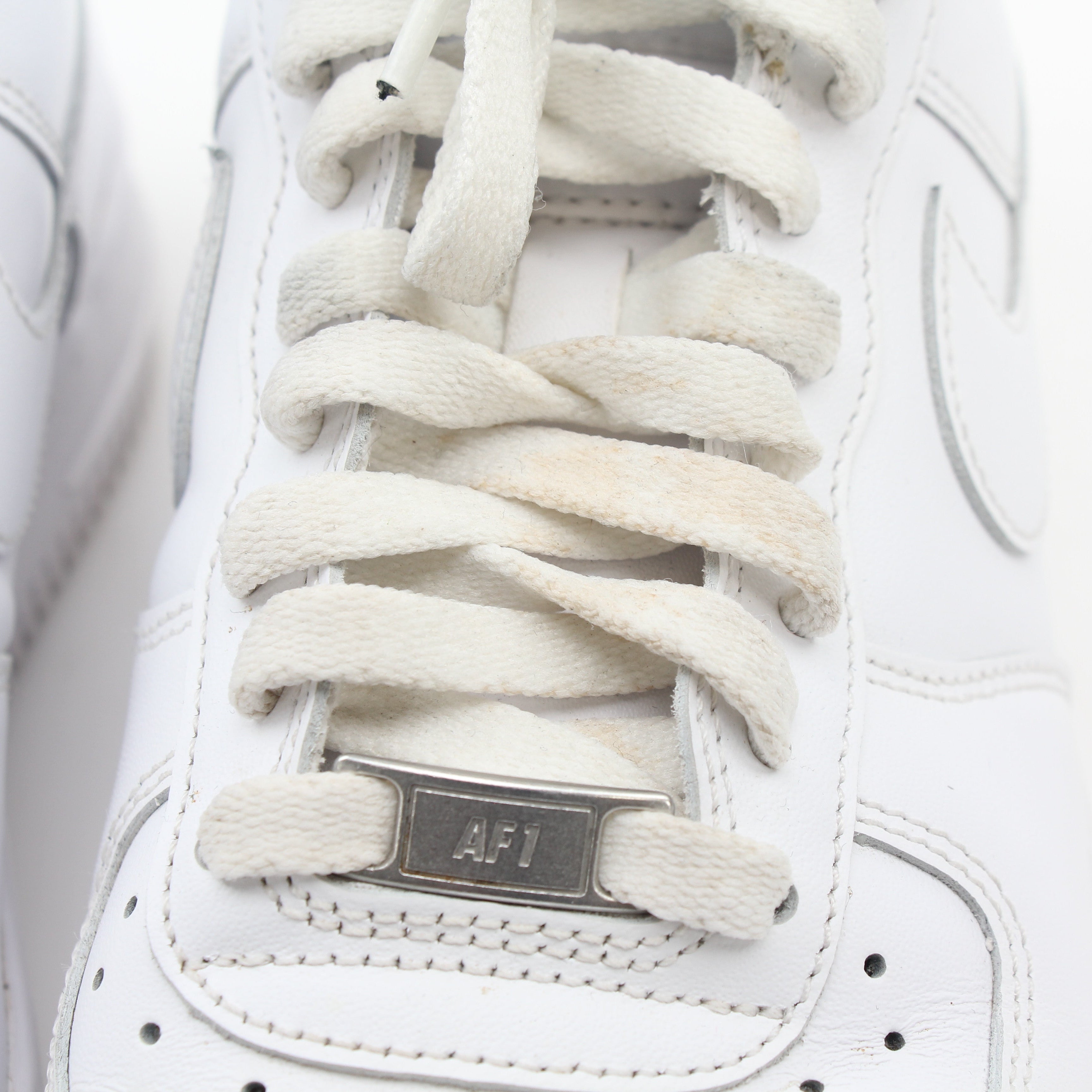 Nike White Air Force 1 ’07 Low sneakers in leather with white laces and rubber soles, displayed on a plain background.