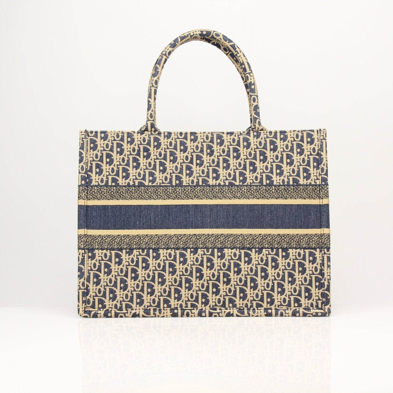 Christian Dior Oblique Book Tote handbag with Dior logo pattern, beige and brown canvas, gold-tone hardware, and top handles.