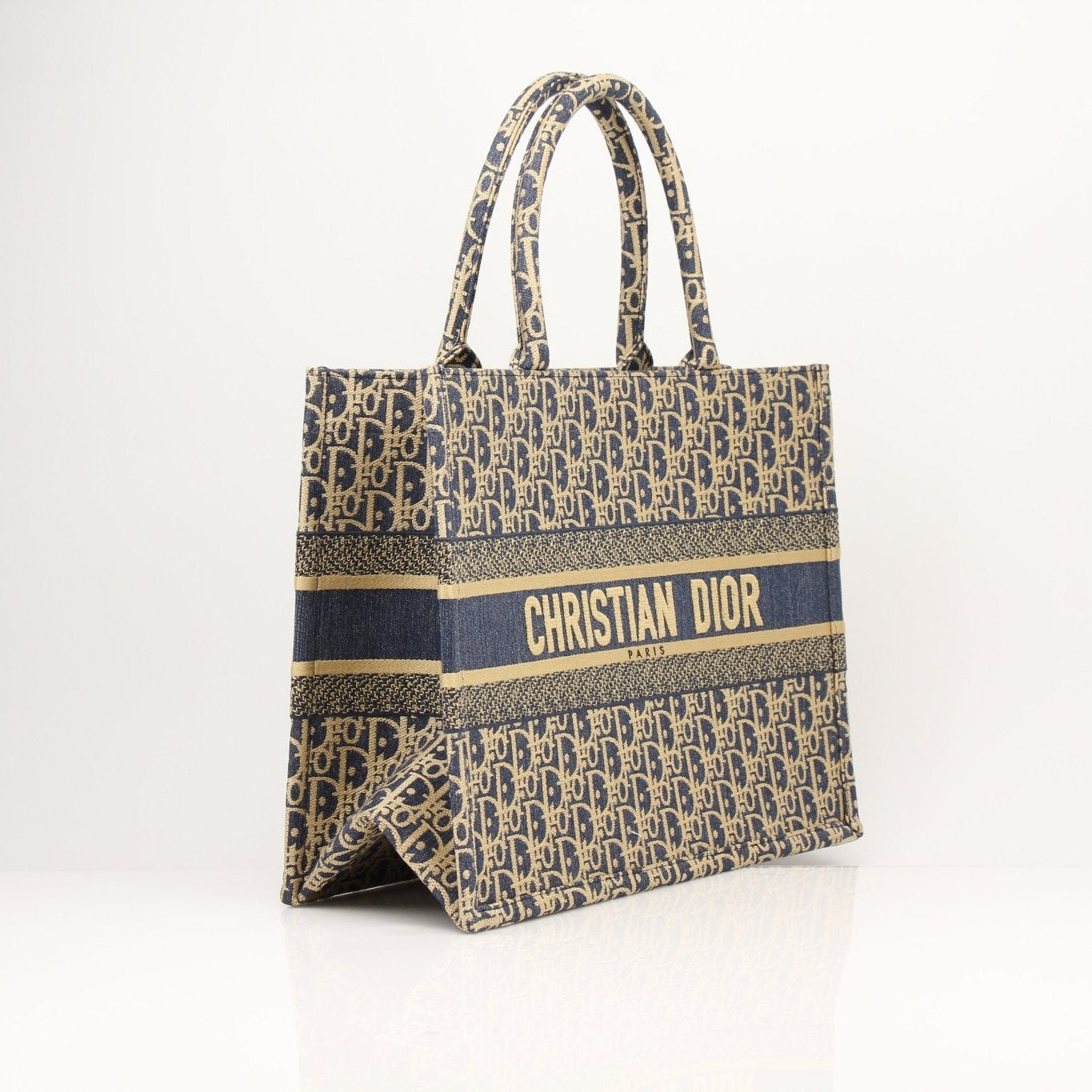 Christian Dior Oblique Book Tote handbag with beige canvas and brown leather trim, featuring the Dior logo pattern.