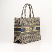 Christian Dior Oblique Book Tote handbag with monogram pattern and leather handles, displayed on a neutral background.