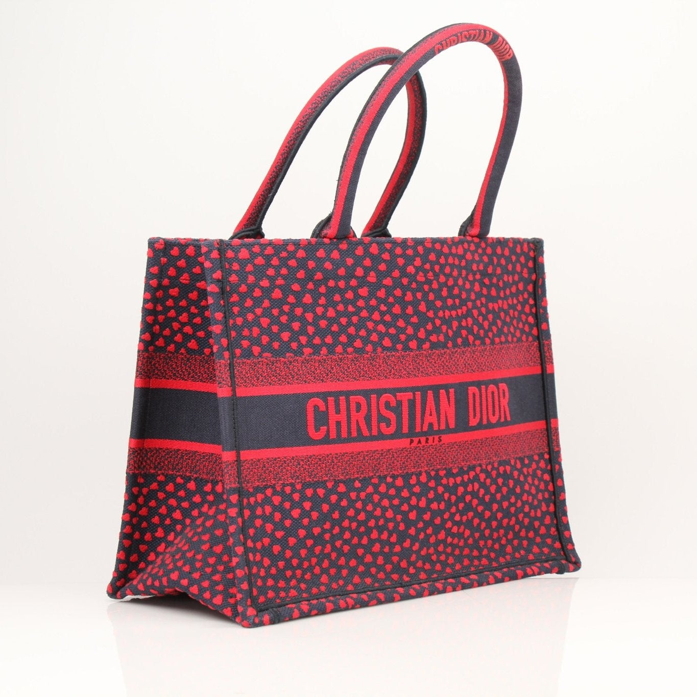 Christian Dior Book Tote handbag with heart embroidery, featuring a spacious design and stylish fabric for everyday use.