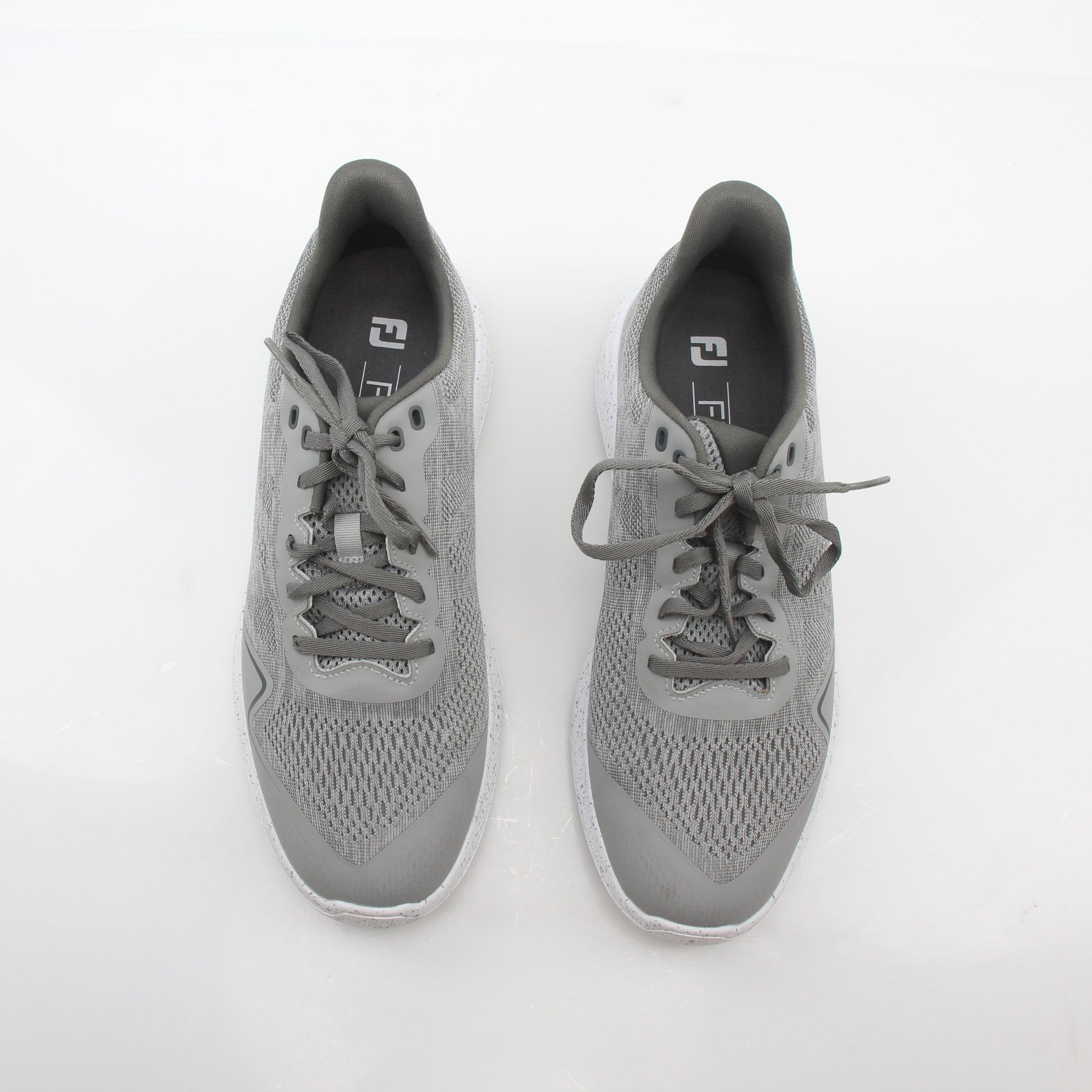 Gray FootJoy Flex spikeless golf shoes with a sleek design, featuring comfortable lacing and a flexible outsole for on-course performance.