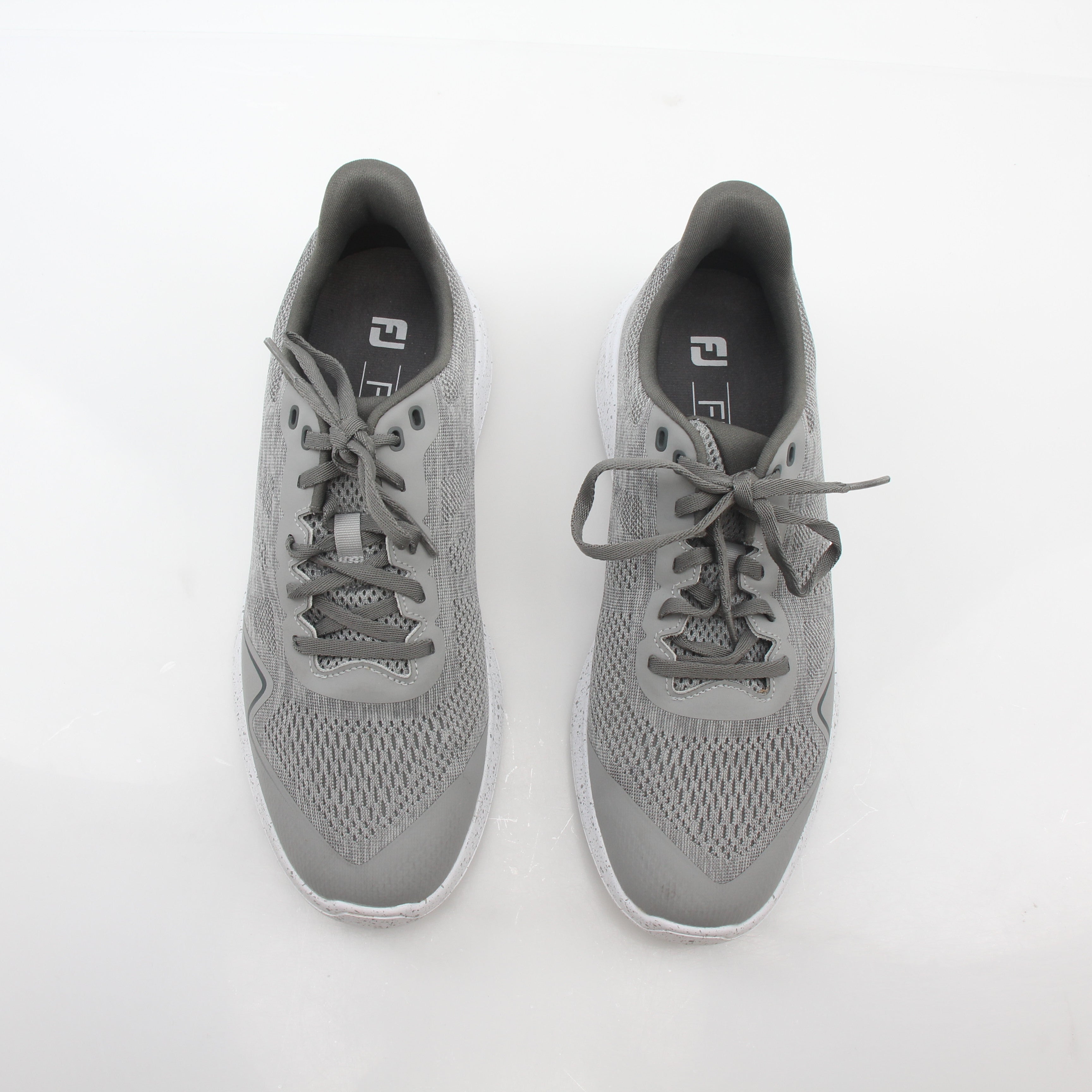 Gray FootJoy Flex spikeless golf shoes with a sleek design, featuring comfortable lacing and a flexible outsole for on-course performance.