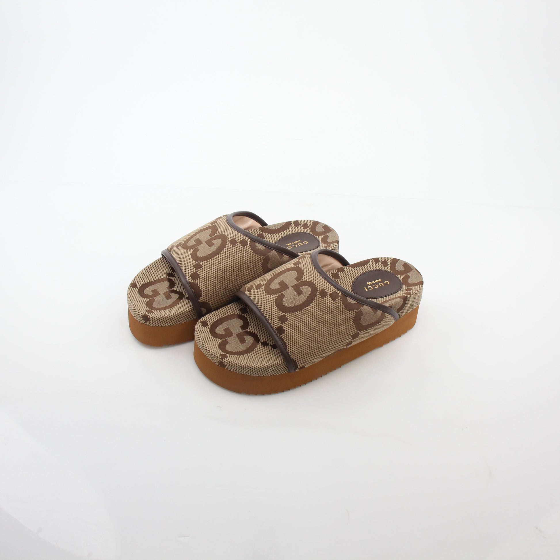 Gold & Beyond Gucci brown maxi GG platform slide sandals with open toe and chunky sole, stylish footwear for casual wear.