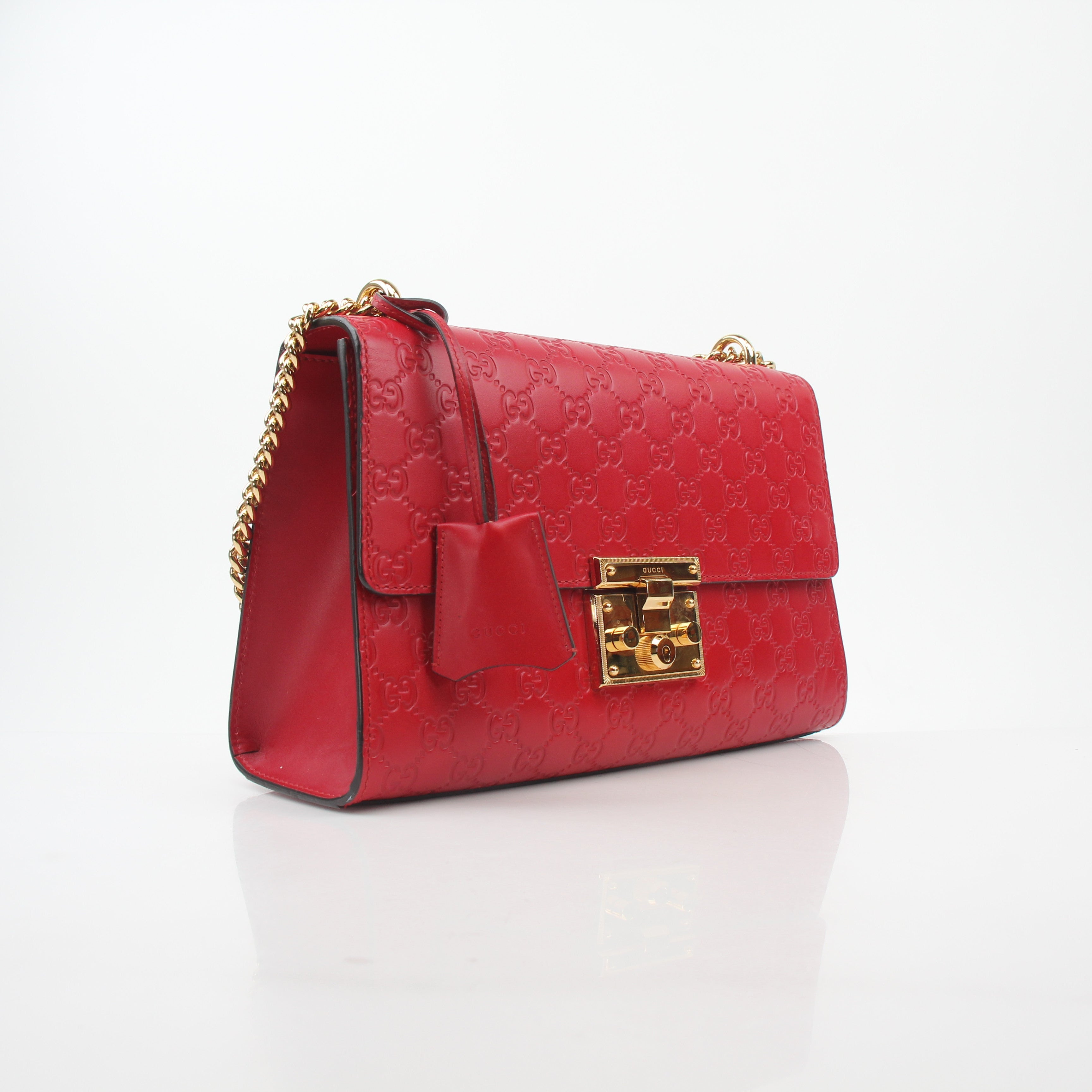 Gucci red GG signature medium shoulder handbag with padlock, featuring gold hardware and a structured leather design.