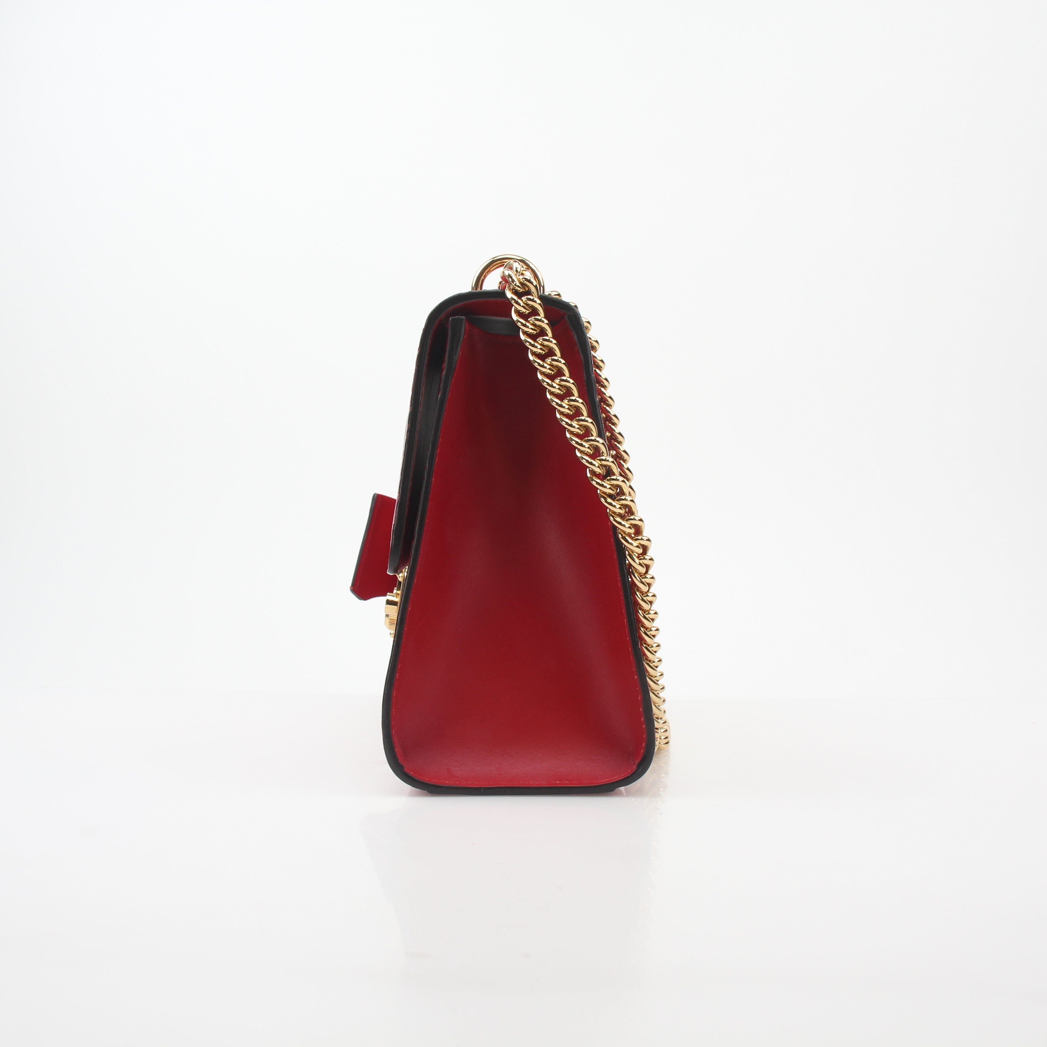 Gucci red GG signature medium shoulder handbag with padlock and gold-tone hardware on a nude background.