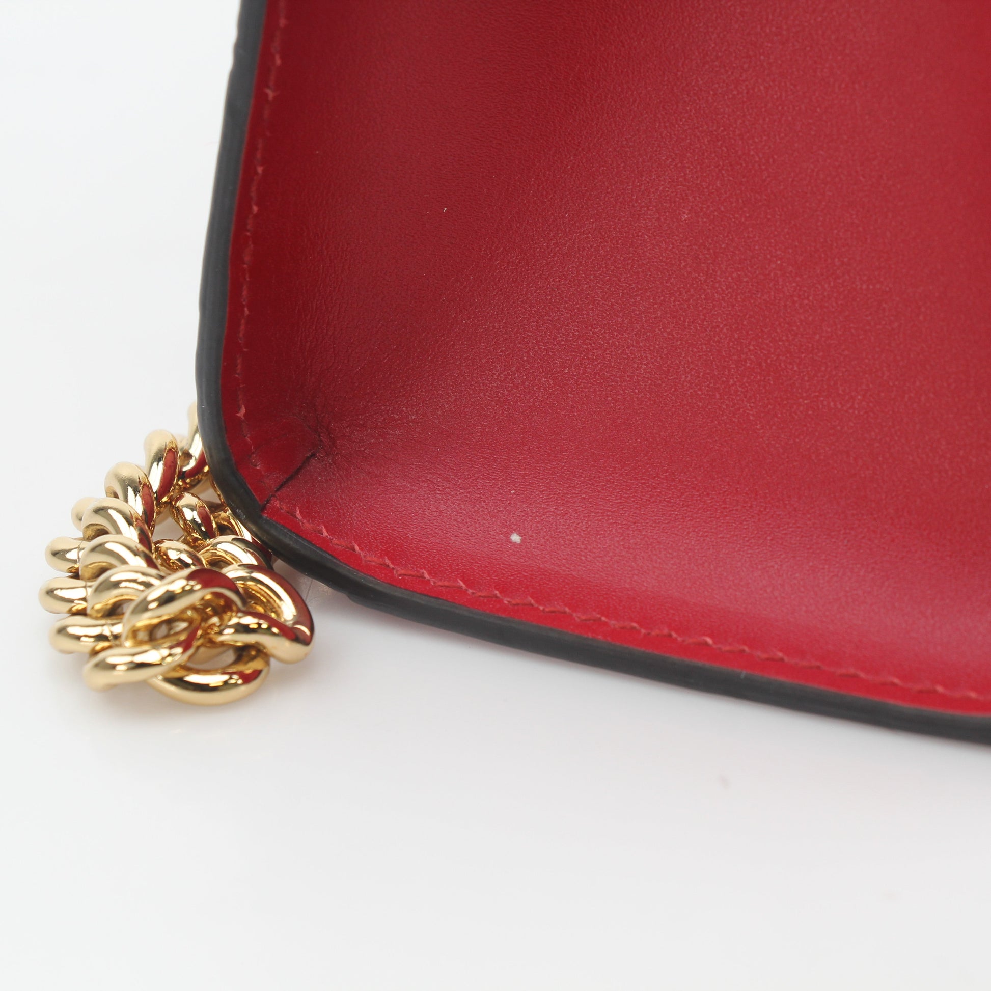 Gucci red GG signature medium shoulder bag with padlock, featuring gold hardware and a sleek leather strap.