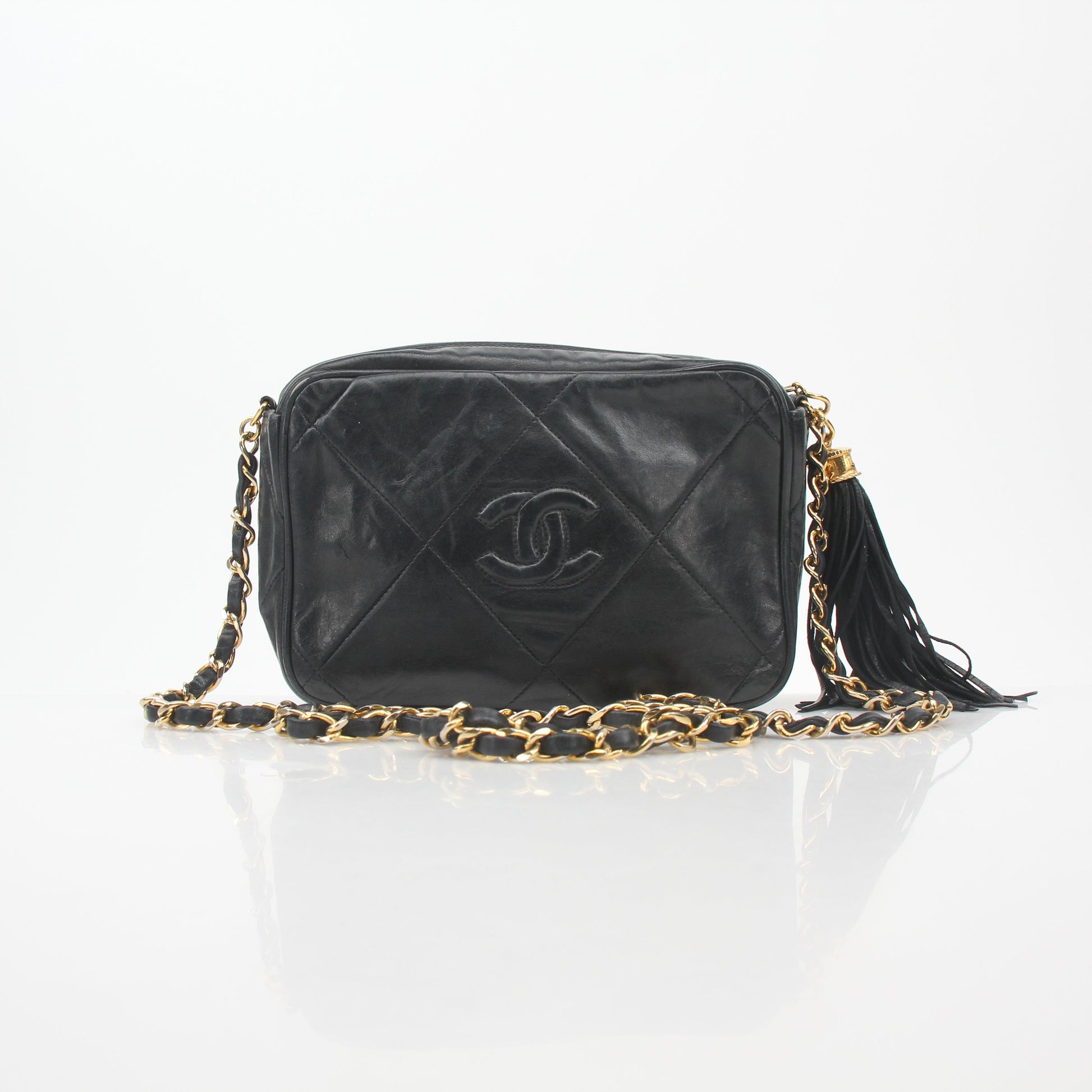 Gold & Beyond Chanel black vintage quilted tassel camera handbag with chain strap and gold accents.