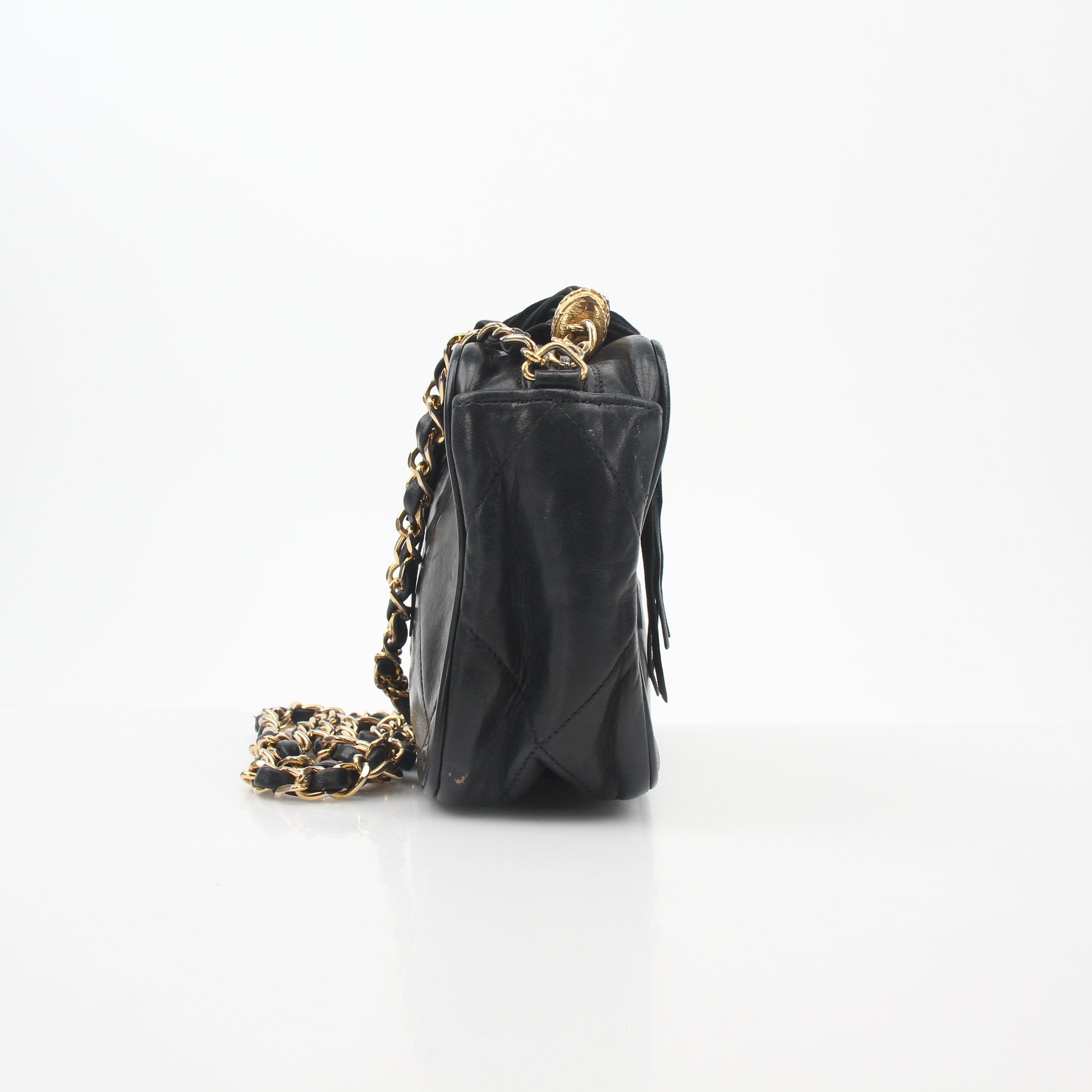 Chanel black vintage quilted tassel camera bag with gold hardware, featuring a hand-stitched leather strap and classic design.