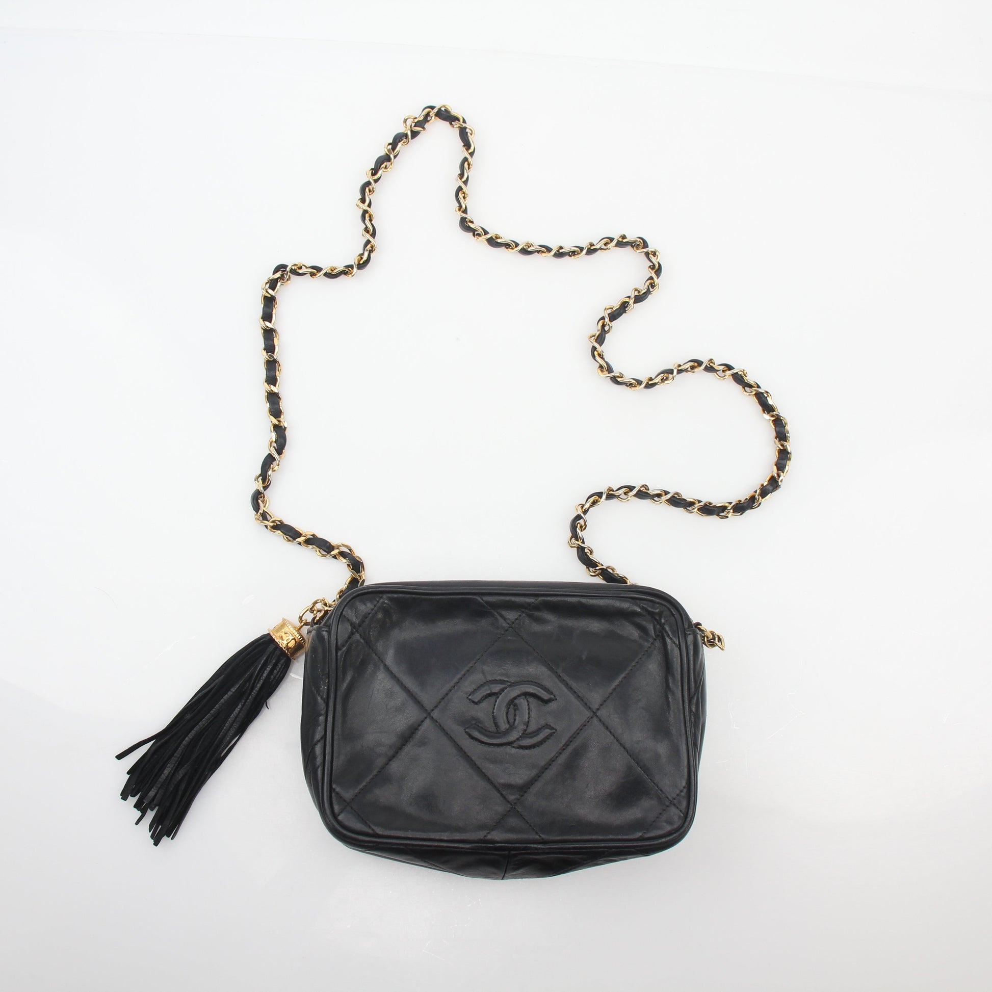 Chanel black vintage quilted tassel camera bag handbag with gold chain strap and gold hardware detail.